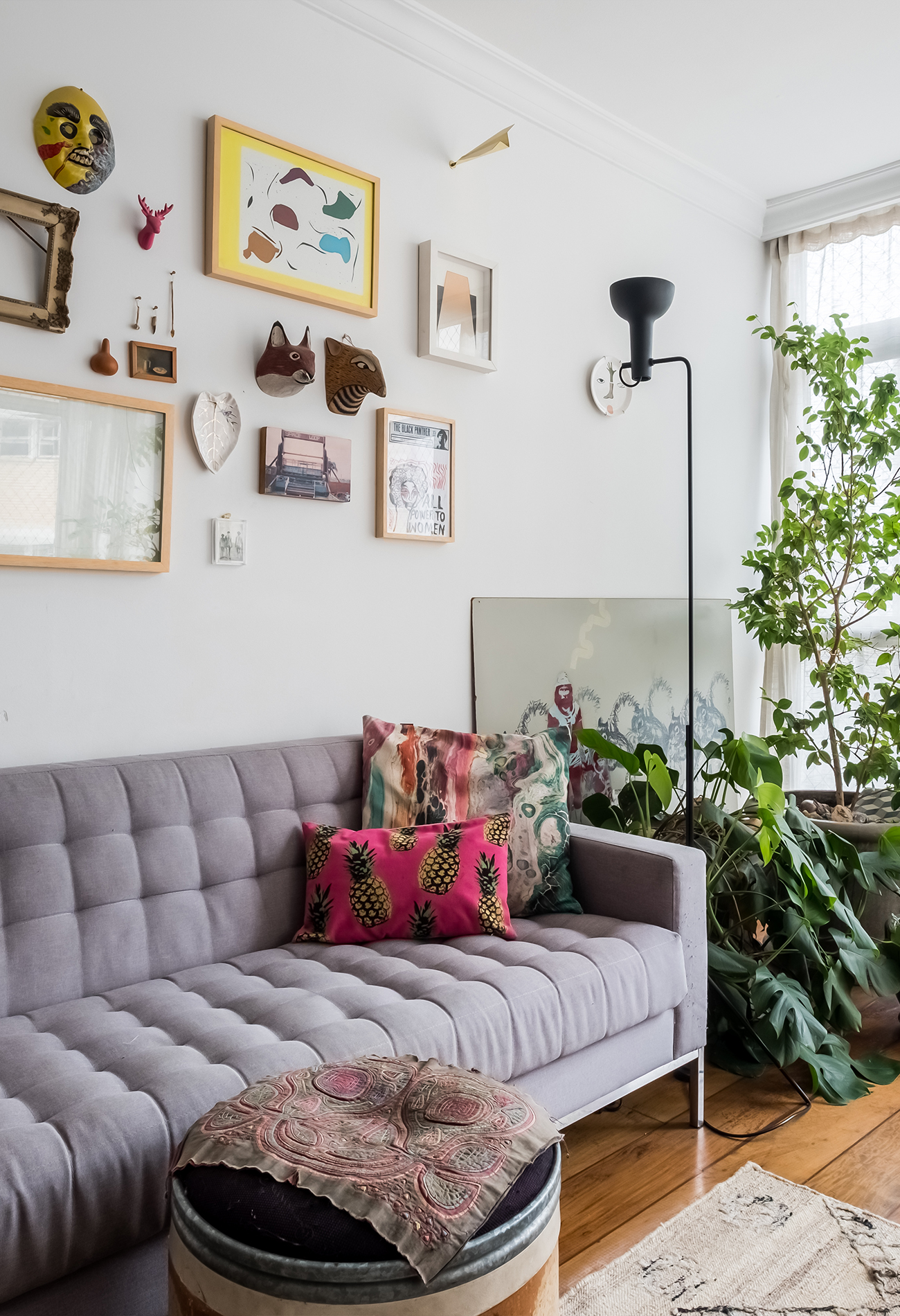 Sala com sofá cinza e plantas