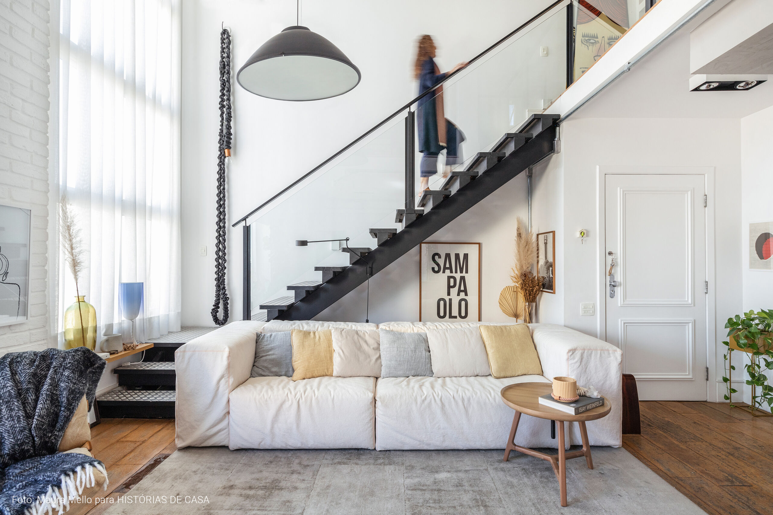 Apartamento duplex com escada de serralheria e sofá branco