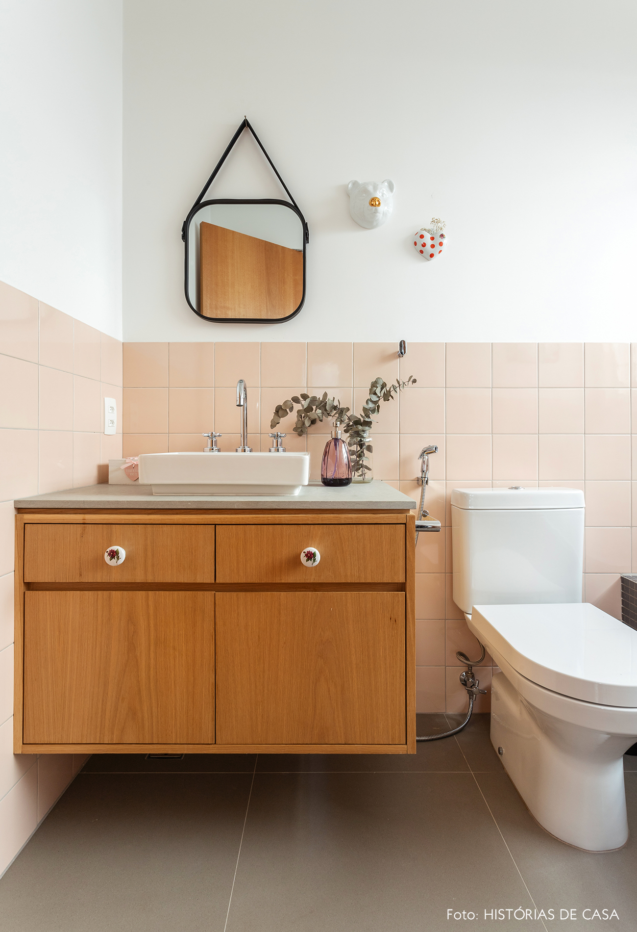 Banheiro com revestimento rosa e marcenaria clara