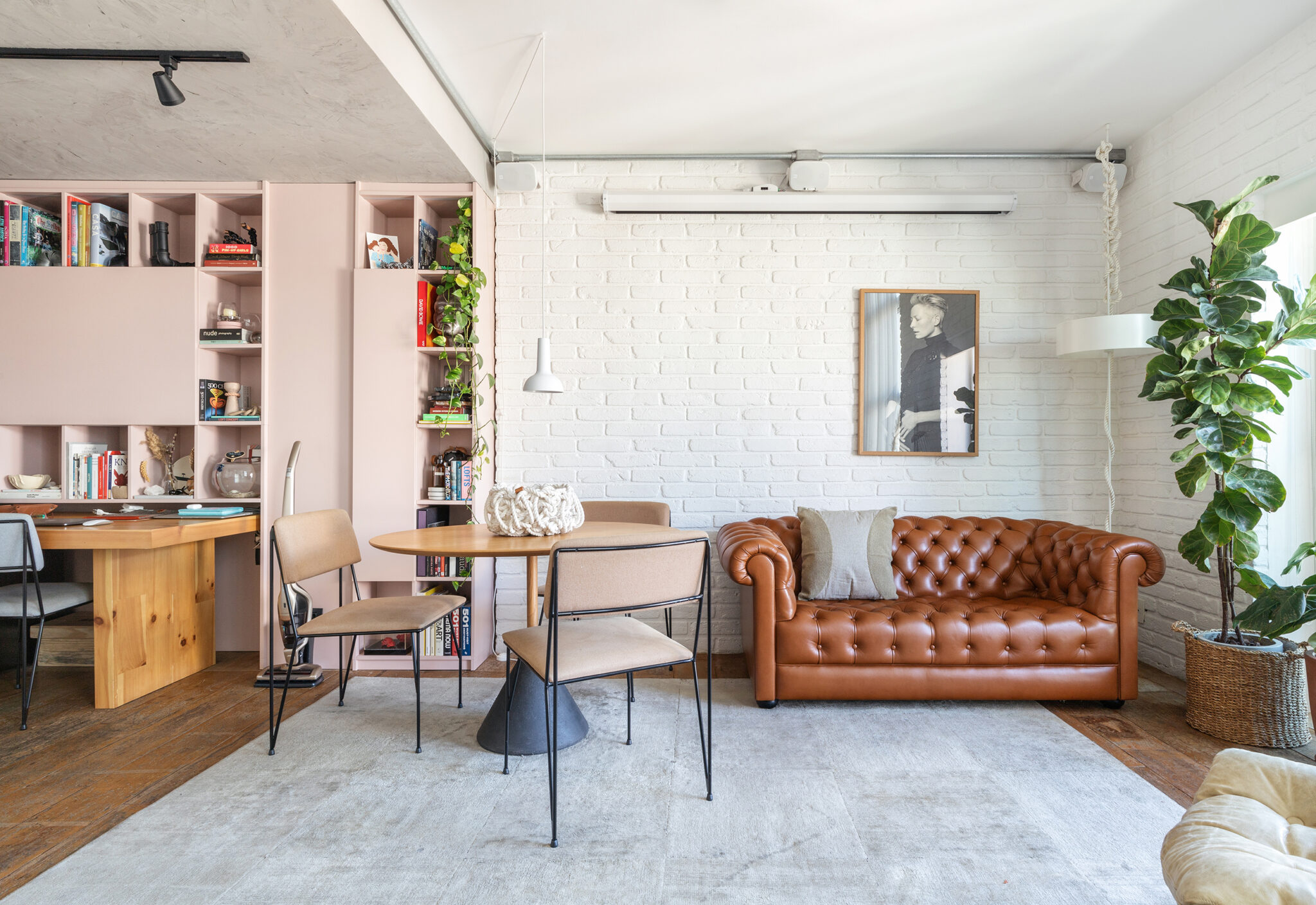 Sala com parede de tijolinho e sofá Chesterfield, apartamento Dre Magalhaes