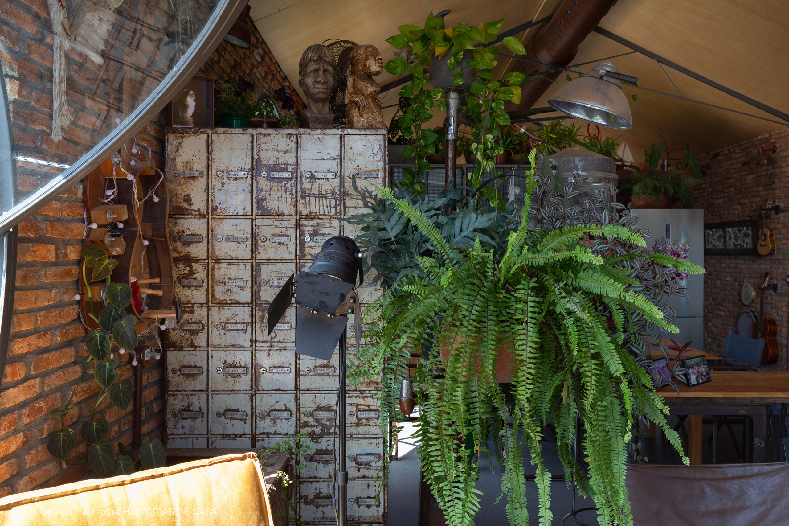 Arquitetura com estilo industrial, casa com tijolinhos e plantas, janelas redondas