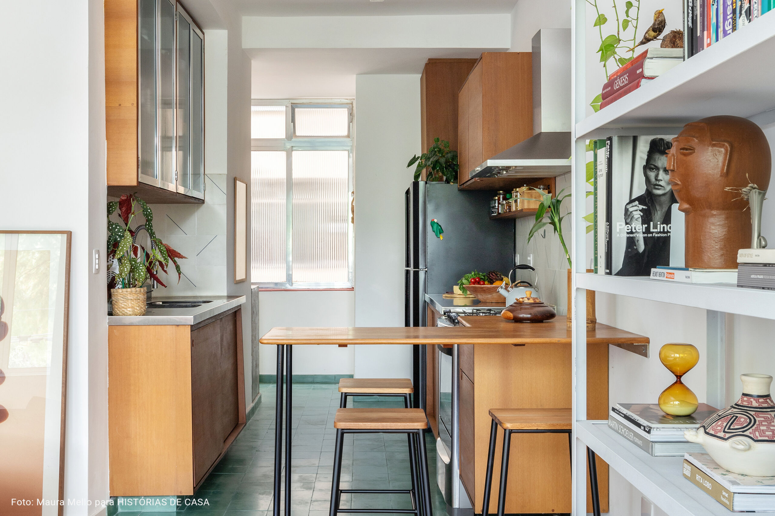 Cozinha integrada com piso verde e geladeira preta
