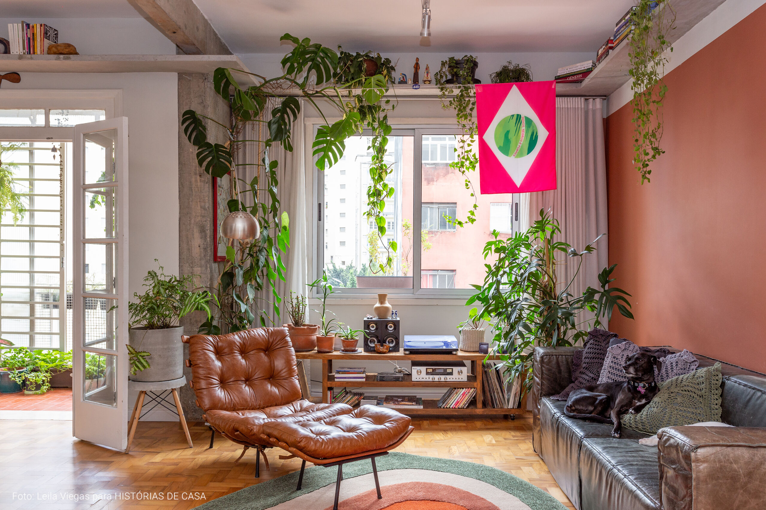 Apartamento com ambientes integrados após reforma e muitas plantas na decoração.