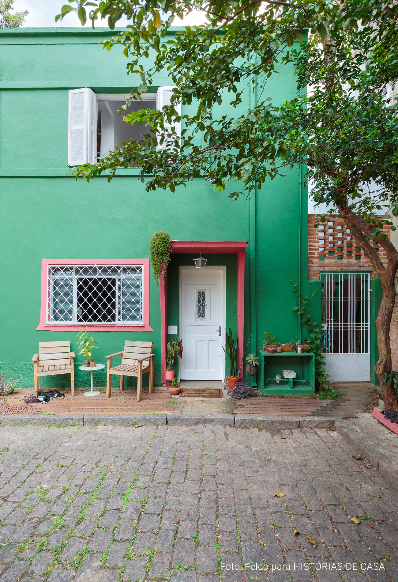 Casa de vila colorida, com fachada verde, quintal e ambientes integrados