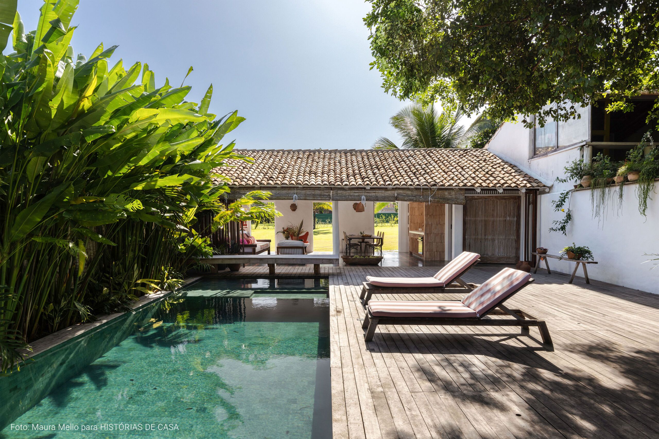 Casa com decoração praiana, uso de materiais naturais e área externa com piscina