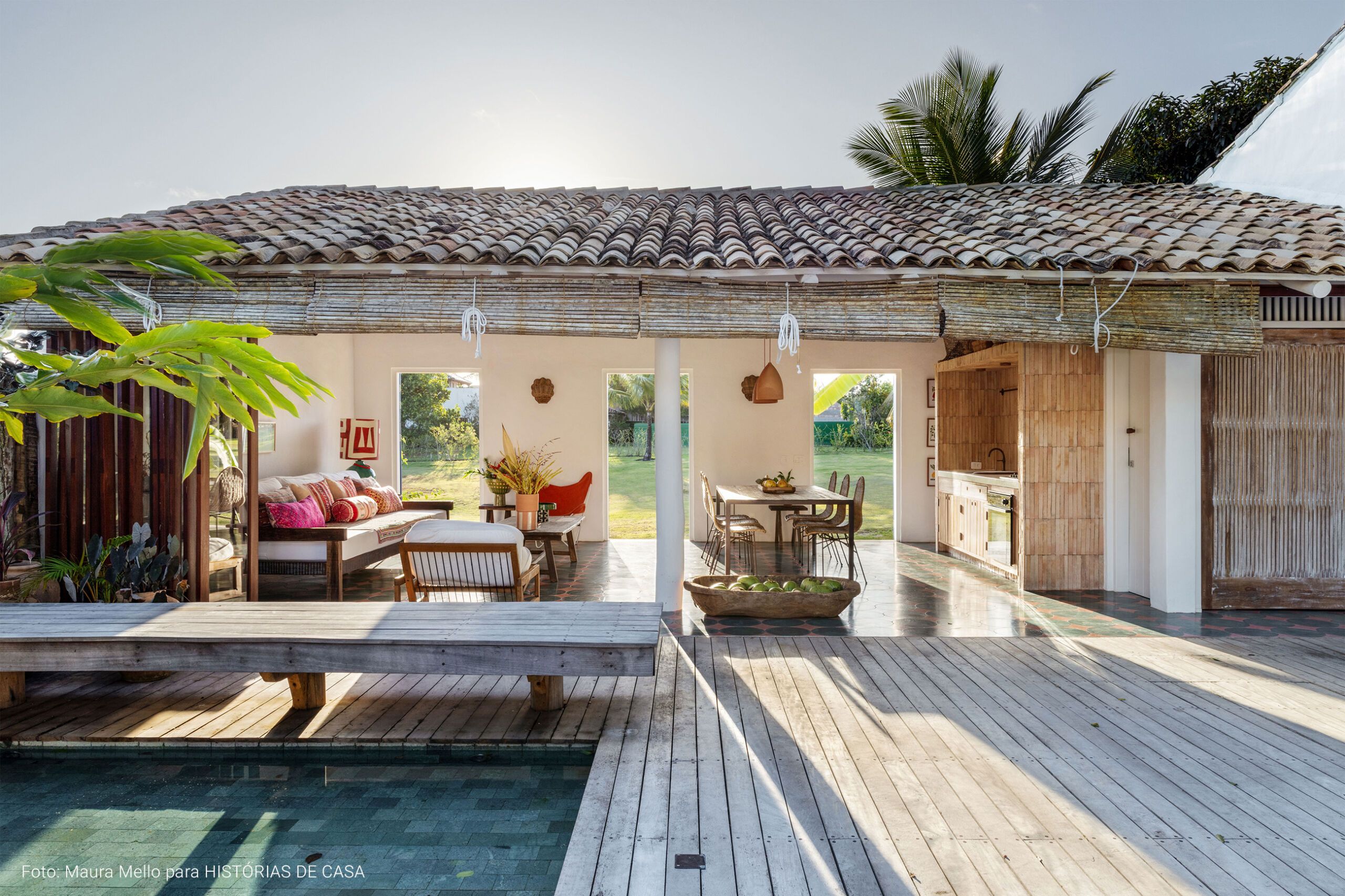 Casa com decoração praiana, uso de materiais naturais e área externa com piscina