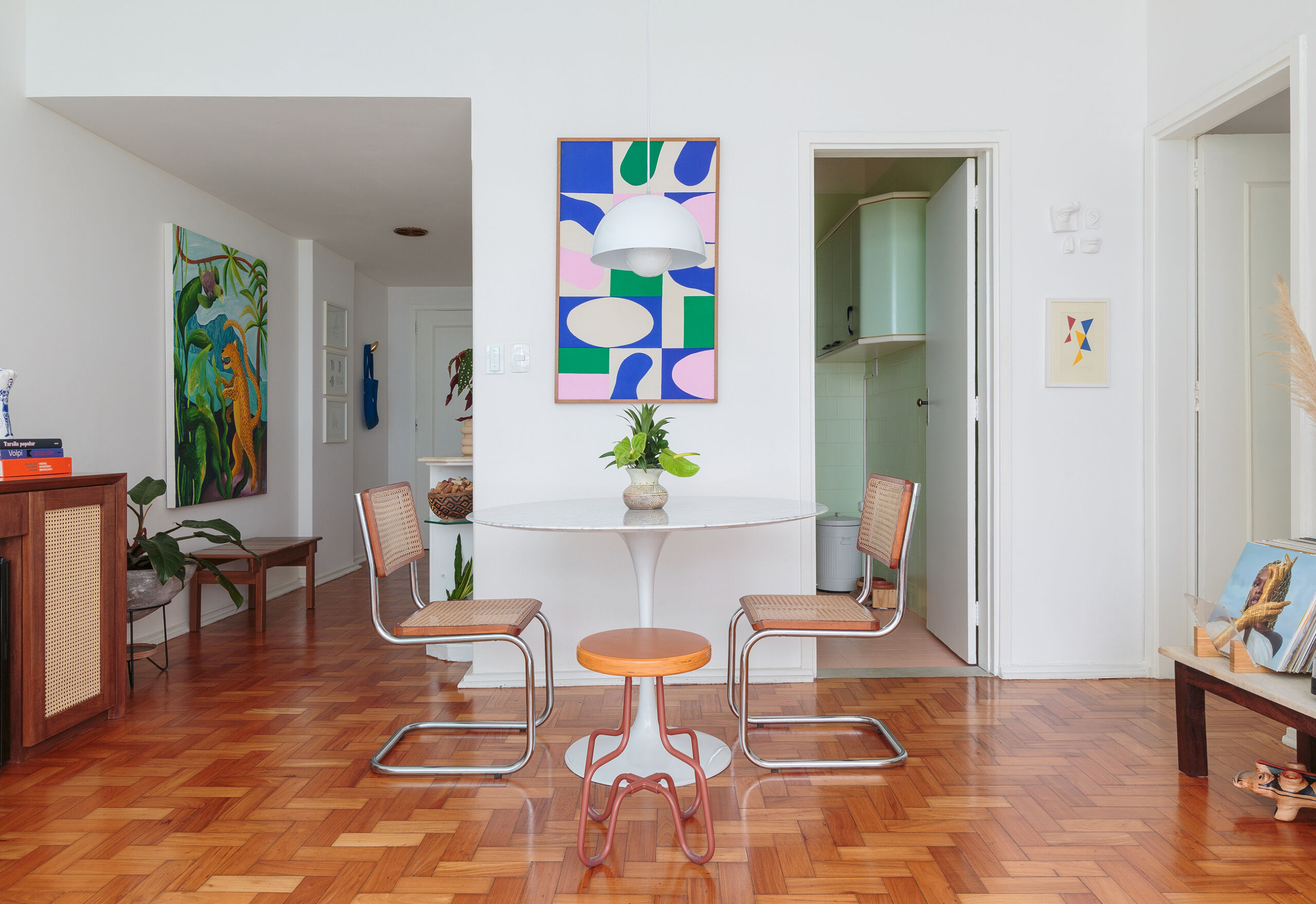 Apartamento com piso de taco, quadros e janelão em Copacabana, no Rio de Janeiro.