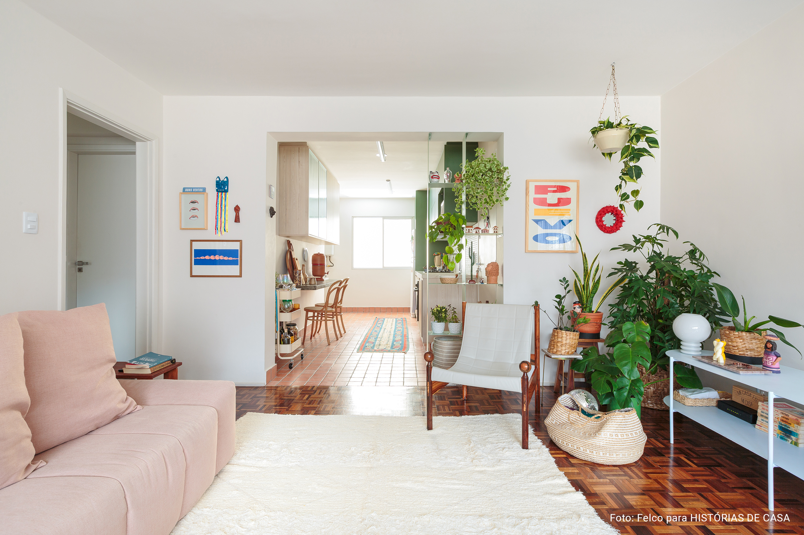 Apartamento alugado colorido com chão de taco e plantas.