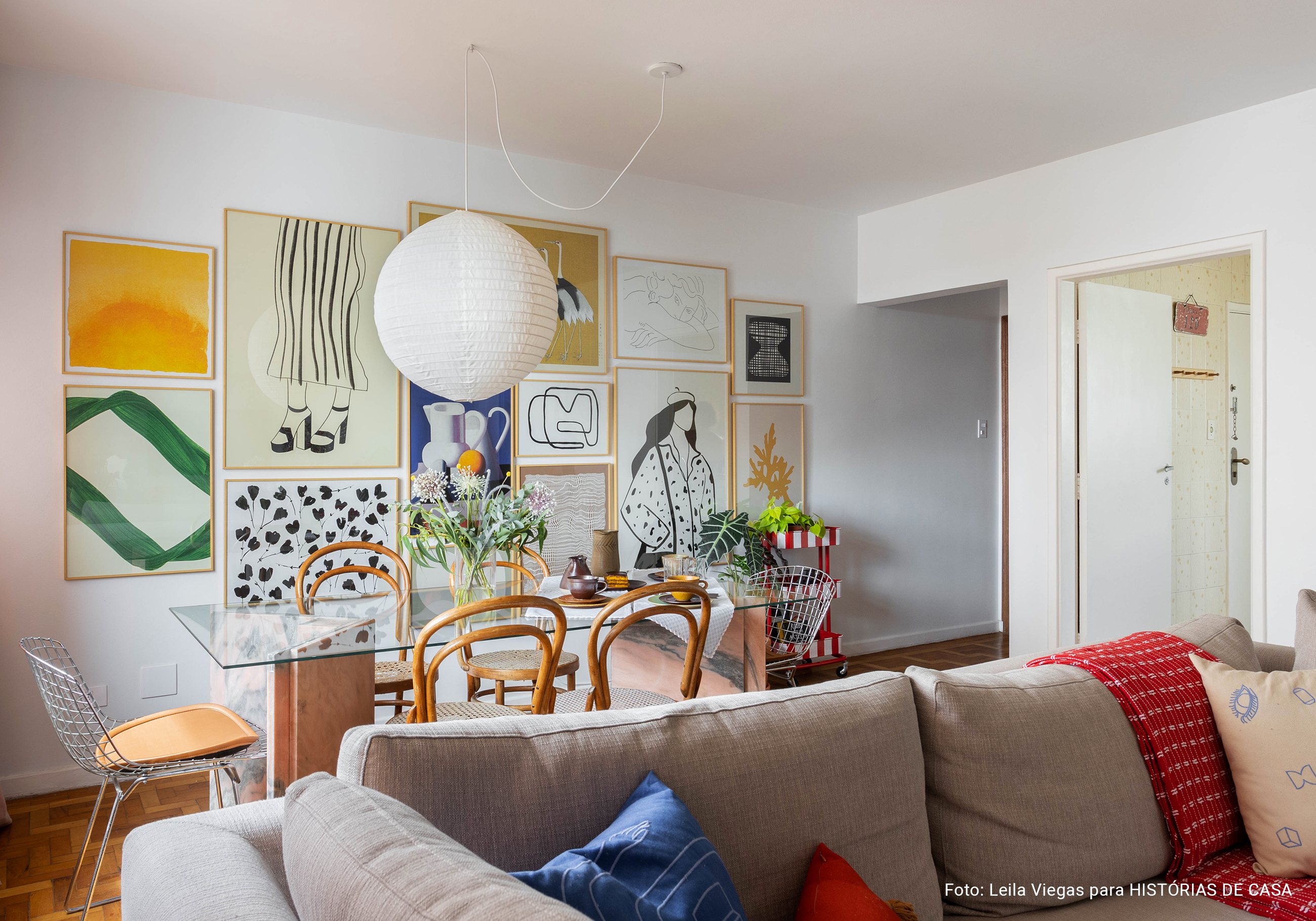 Apartamento com parede de quadros da Boemi, piso de tacos e decoração com móveis garimpados.