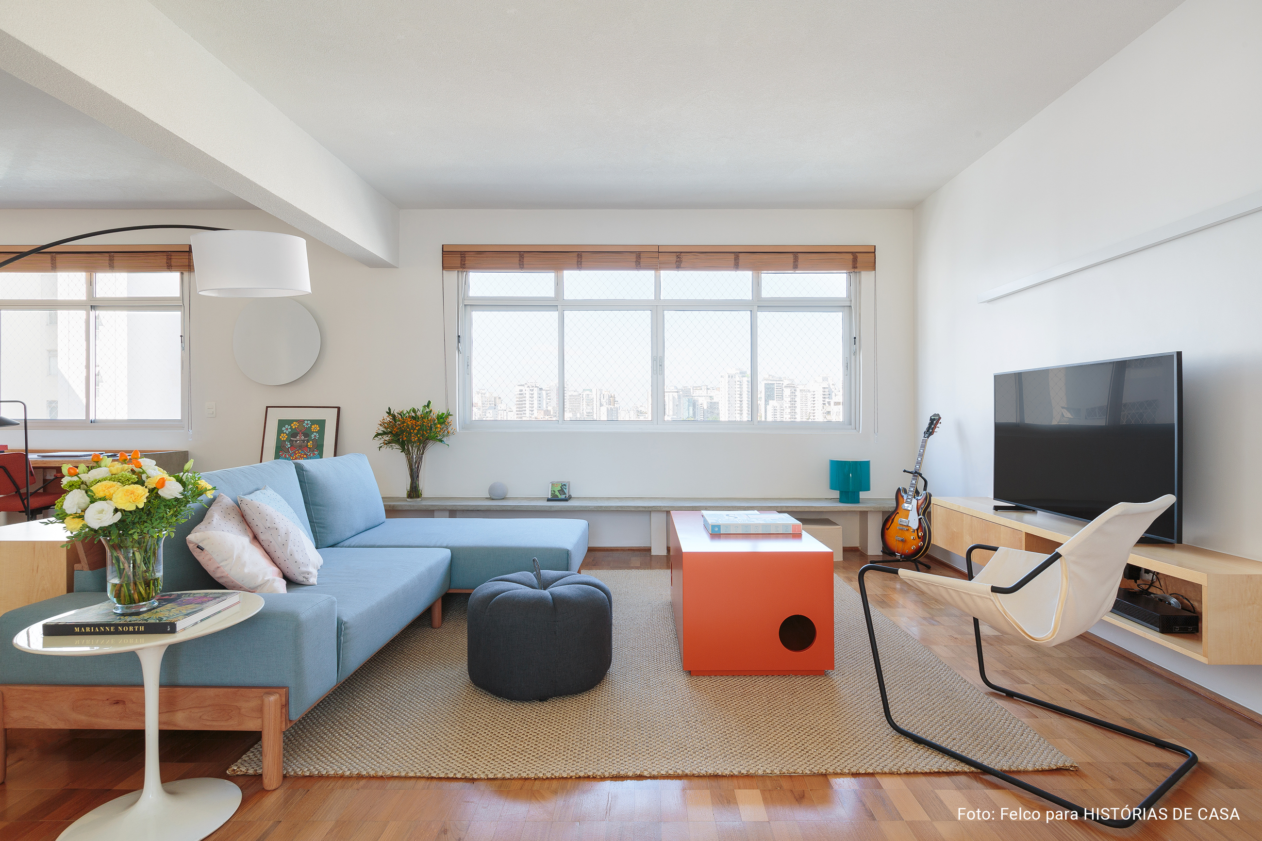 Apartamento integrado com sofá azul e marcenaria sob medida