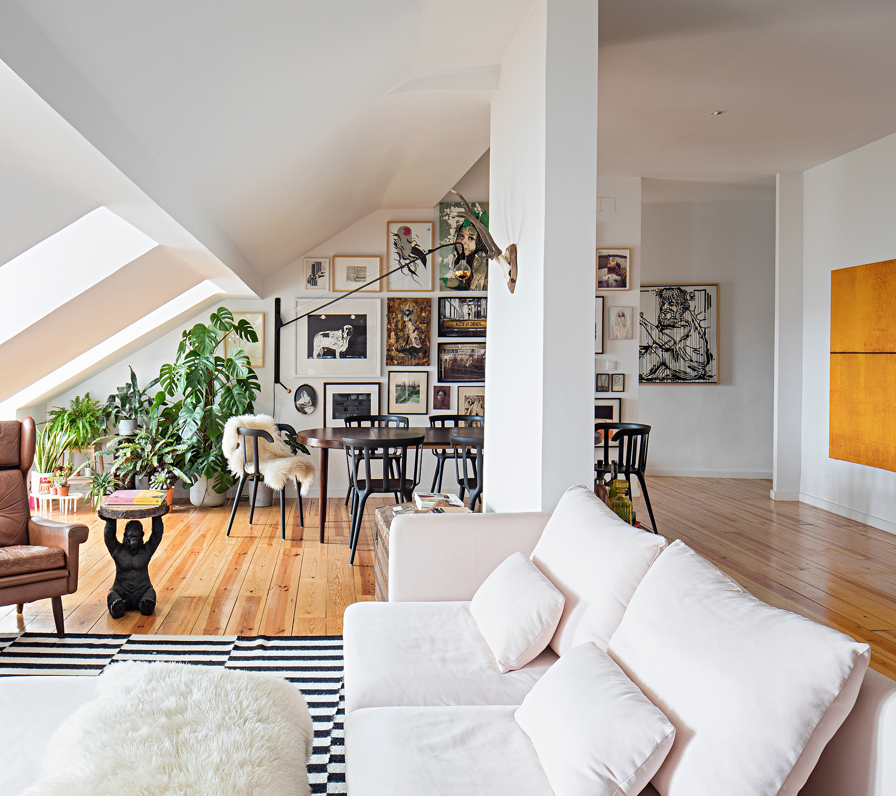 Apartamento de brasileiros em Portugal com muitos quadros e esculturas.