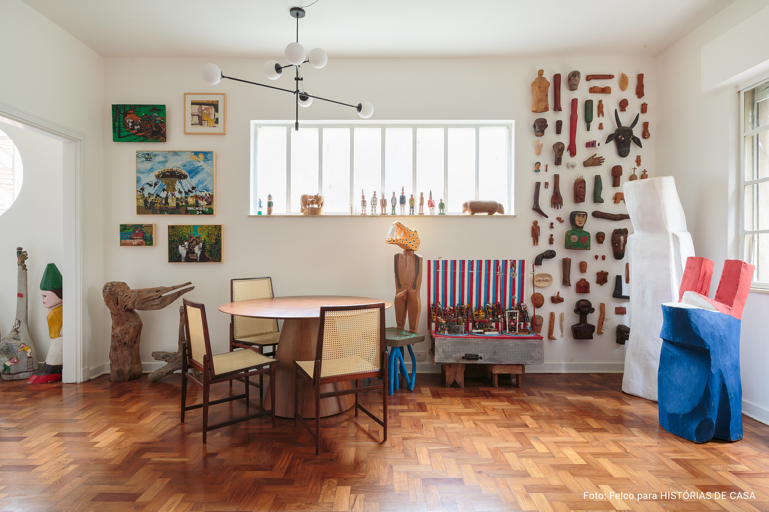 Artesanato e arte popular em apartamento com piso de tacos e luz natural.