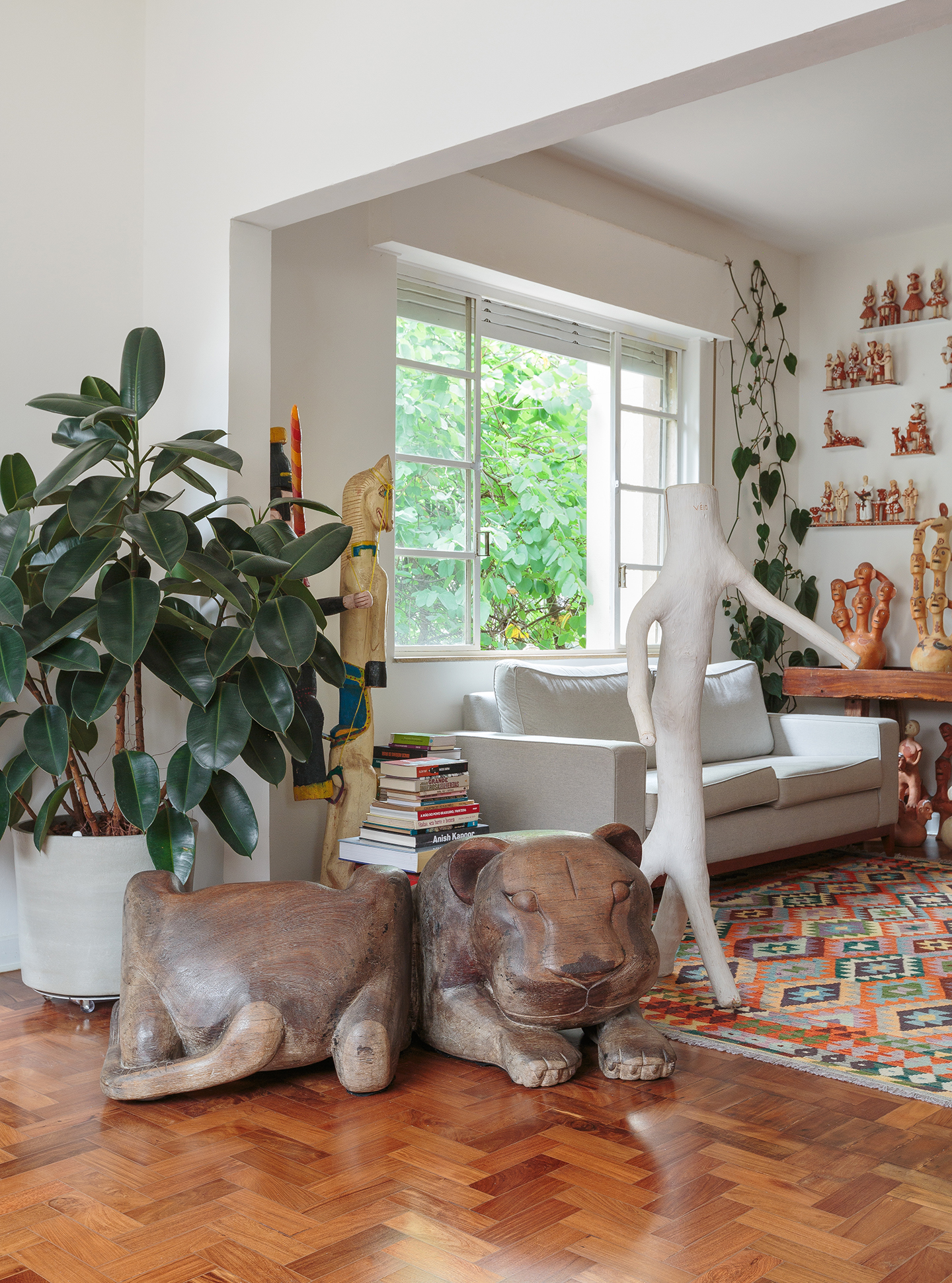 Artesanato e arte popular em apartamento com piso de tacos e luz natural.