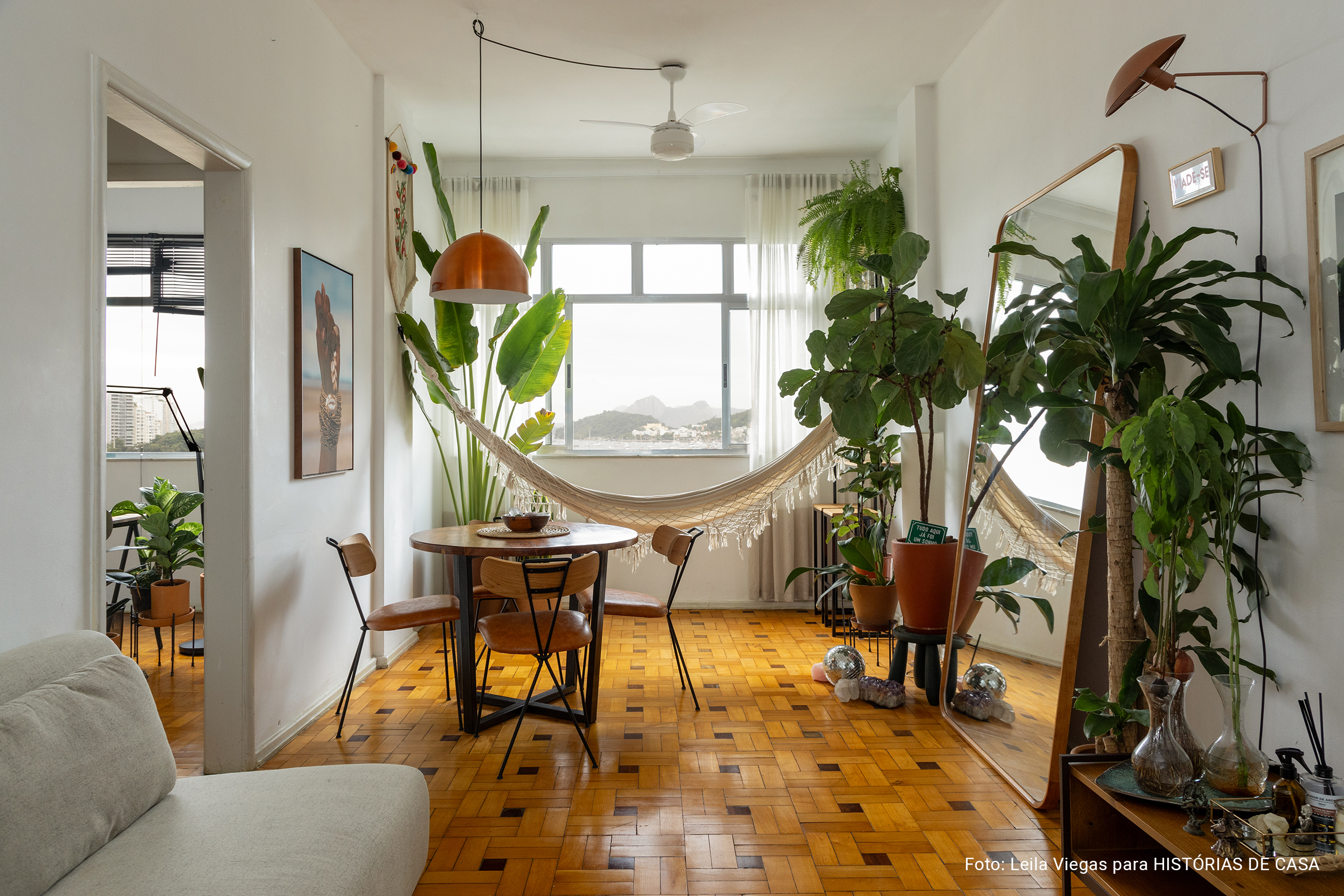 Apartamento com vista para a praia no Rio de Janeiro tem piso de tacos e decoração com plantas.