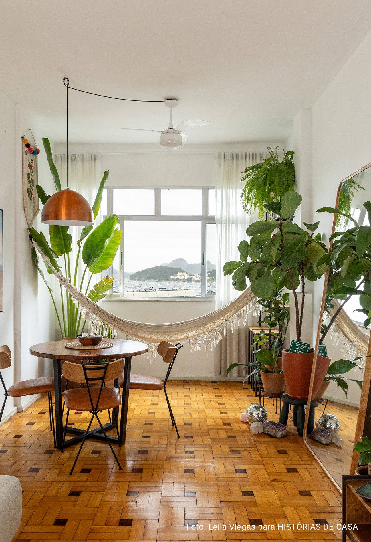 Apartamento com vista para a praia no Rio de Janeiro tem piso de tacos e decoração com plantas.