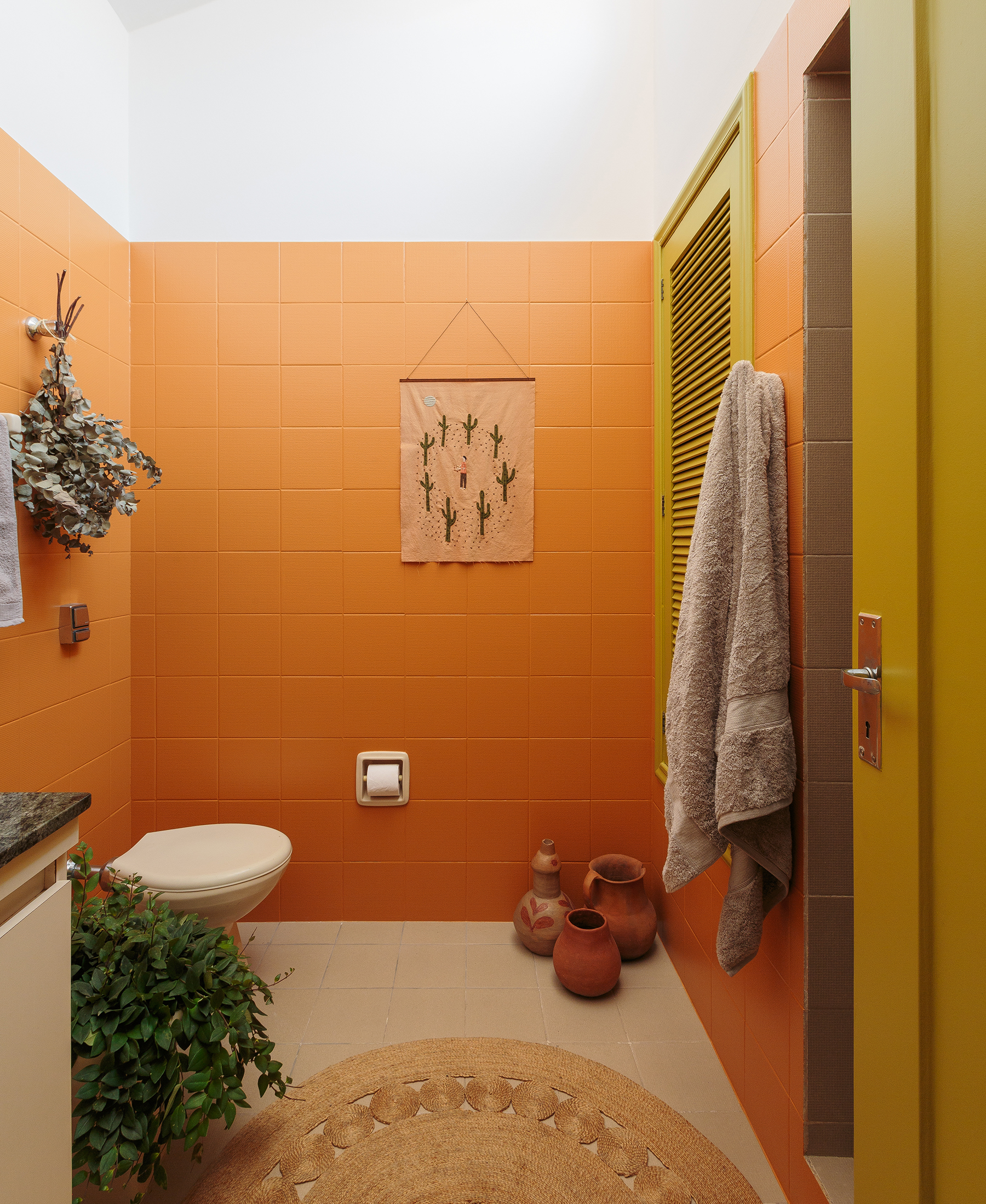 Antes e depois de banheiro colorido com azulejos pintados e decoração rústica