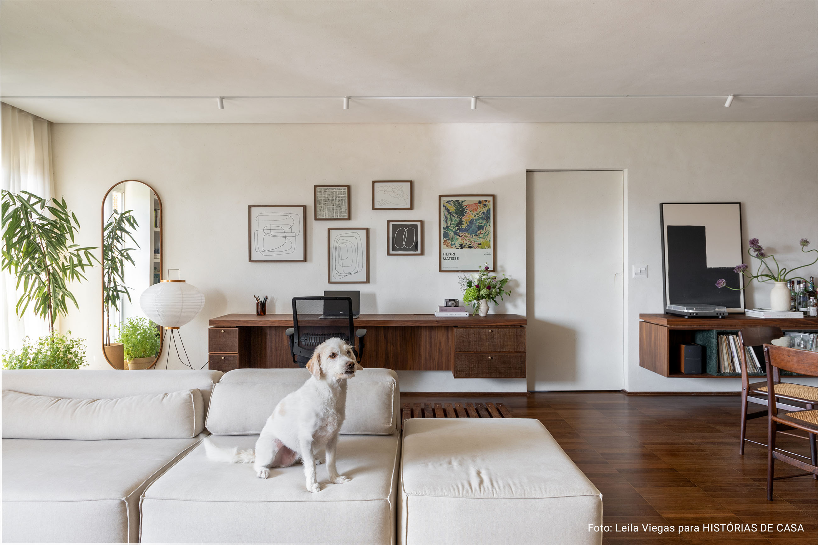 Apartamento com decoracão aconchegante e minimalista com cores neutras e quadros nas paredes.