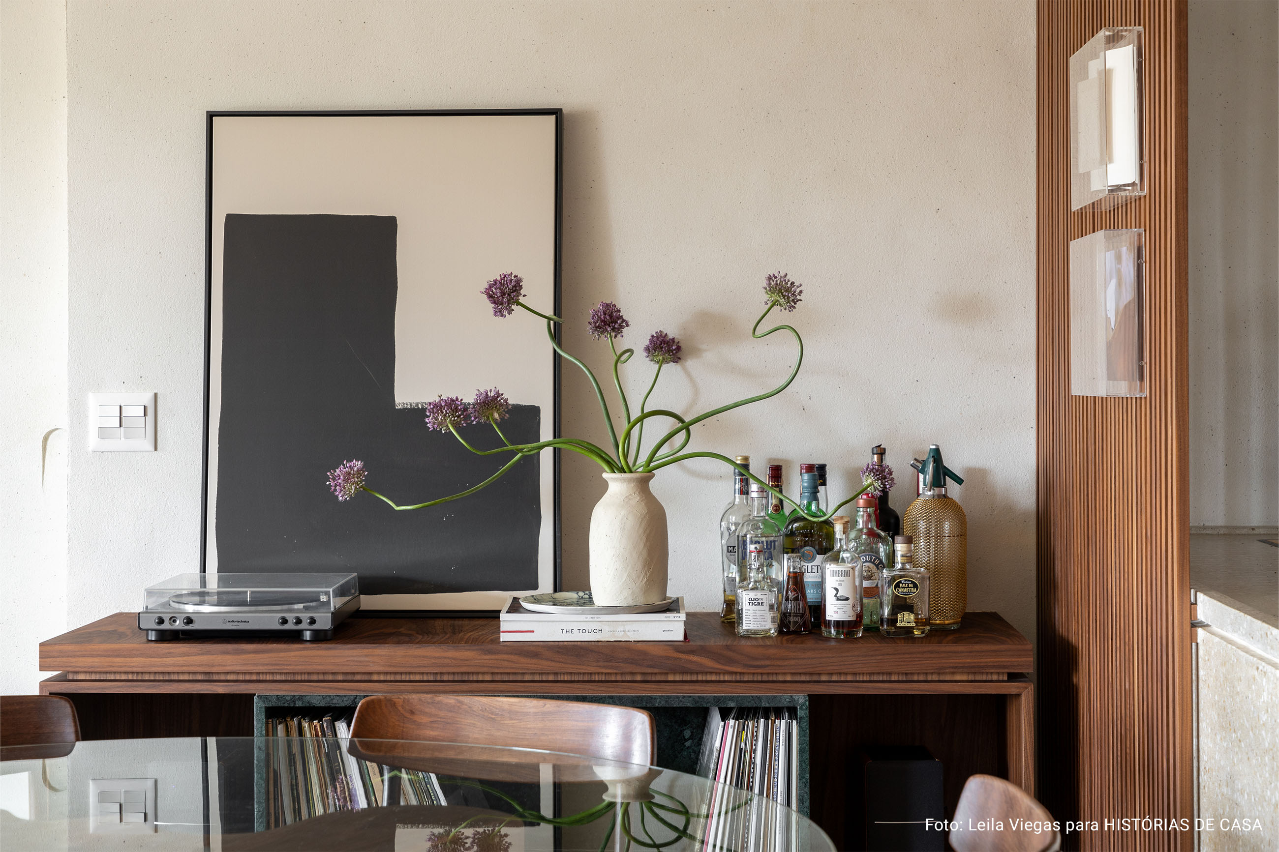 Apartamento com decoracão aconchegante e minimalista com cores neutras e quadros nas paredes.