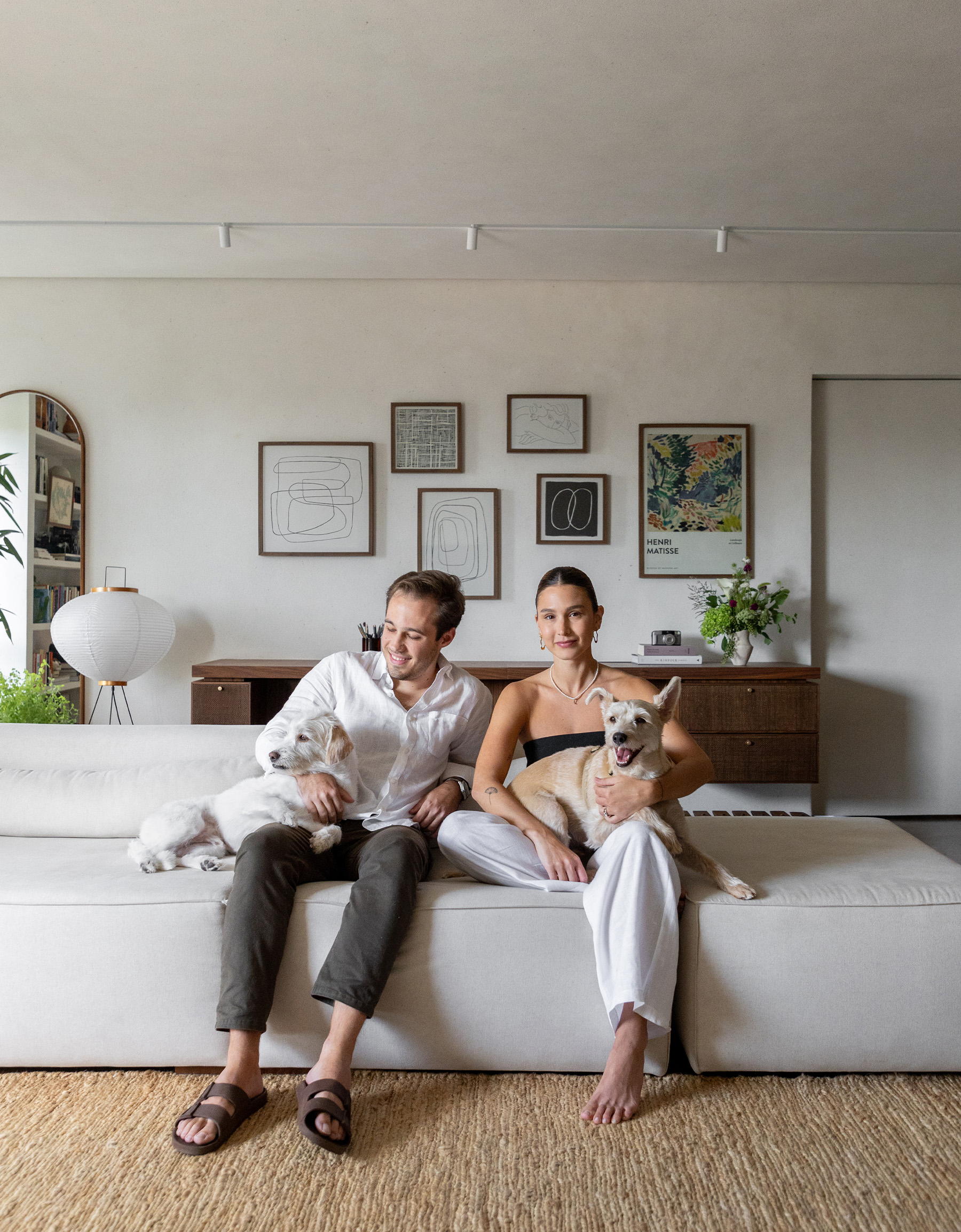 Casa minimalista com parede de quadros e móveis de família