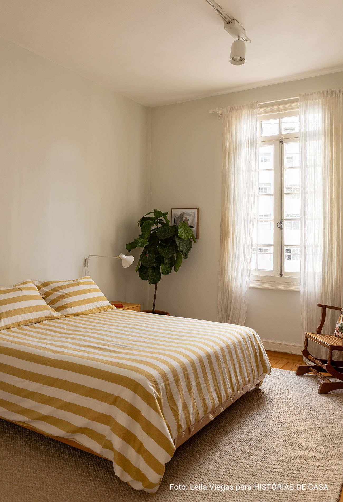 Apartamento antigo com sala integrada, luz natural e decoracão em cores neutras.