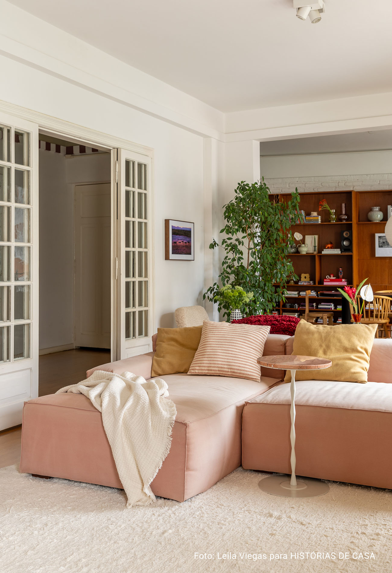 Apartamento antigo com sala integrada, luz natural e decoracão em cores neutras.