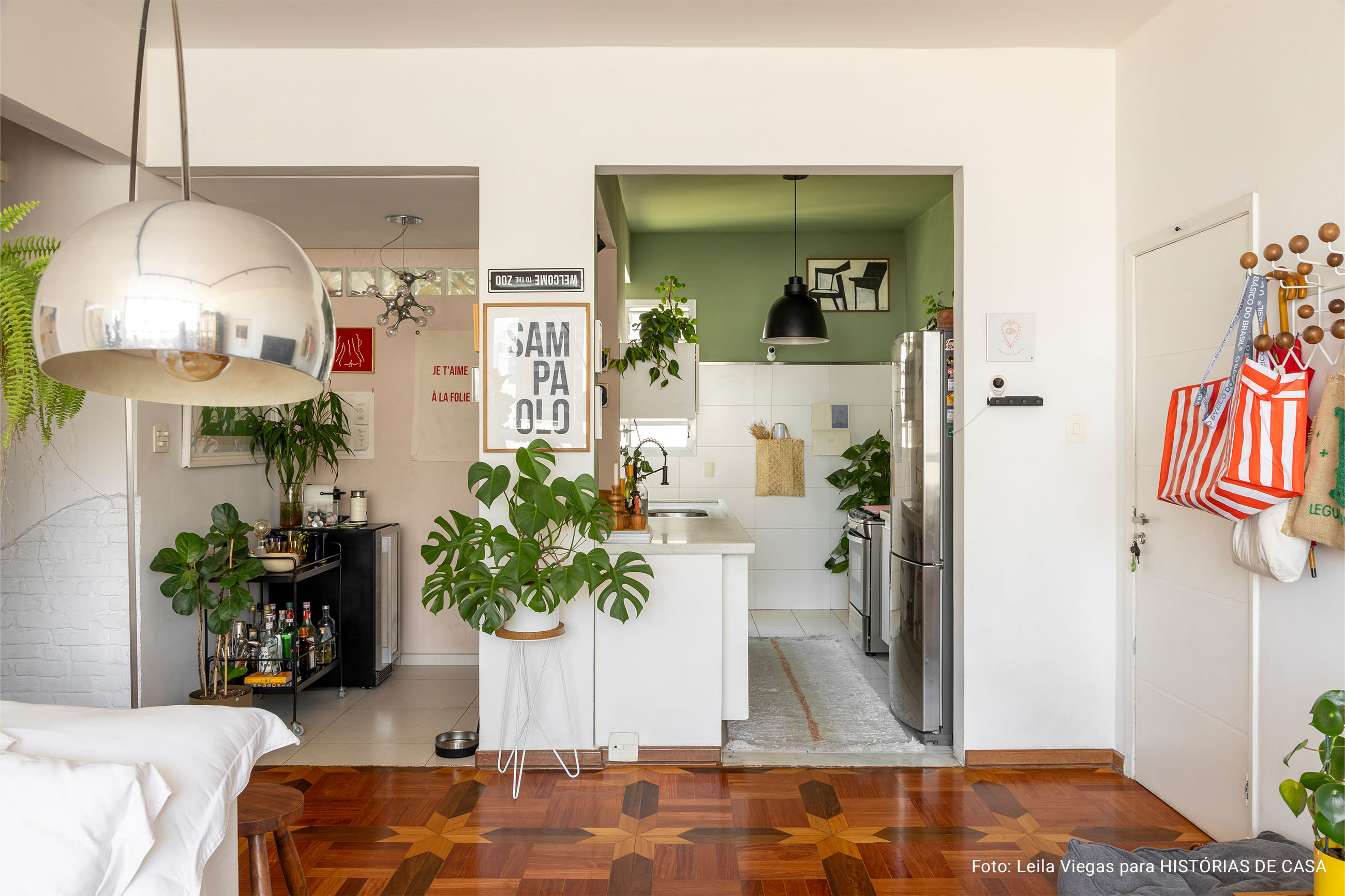 Decoração de apartamento aconchegante com piso de taco, plantas e soluções descomplicadas