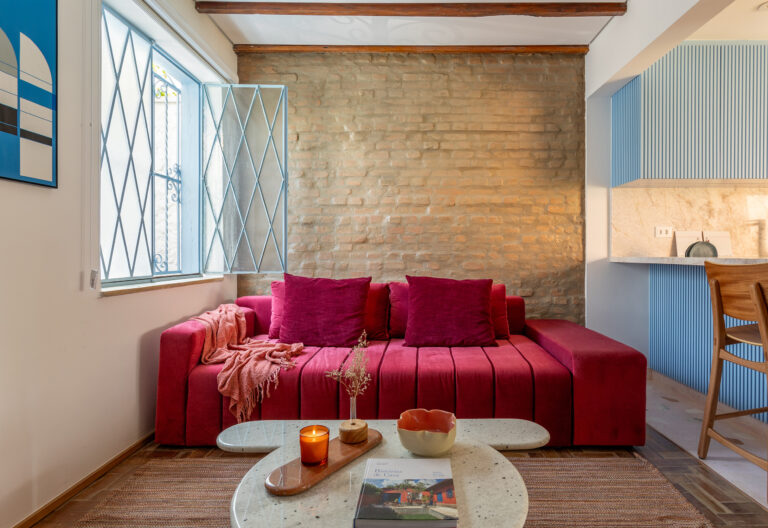 Casa antiga reformada com parede e tijolinhos e quintal.