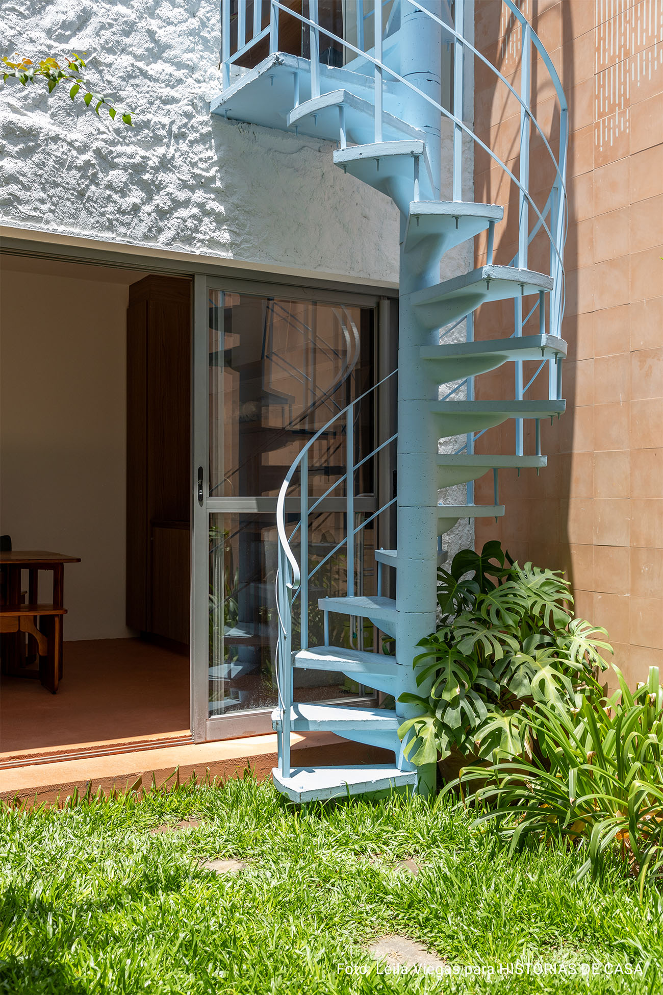 Casa antiga reformada com parede e tijolinhos e quintal.