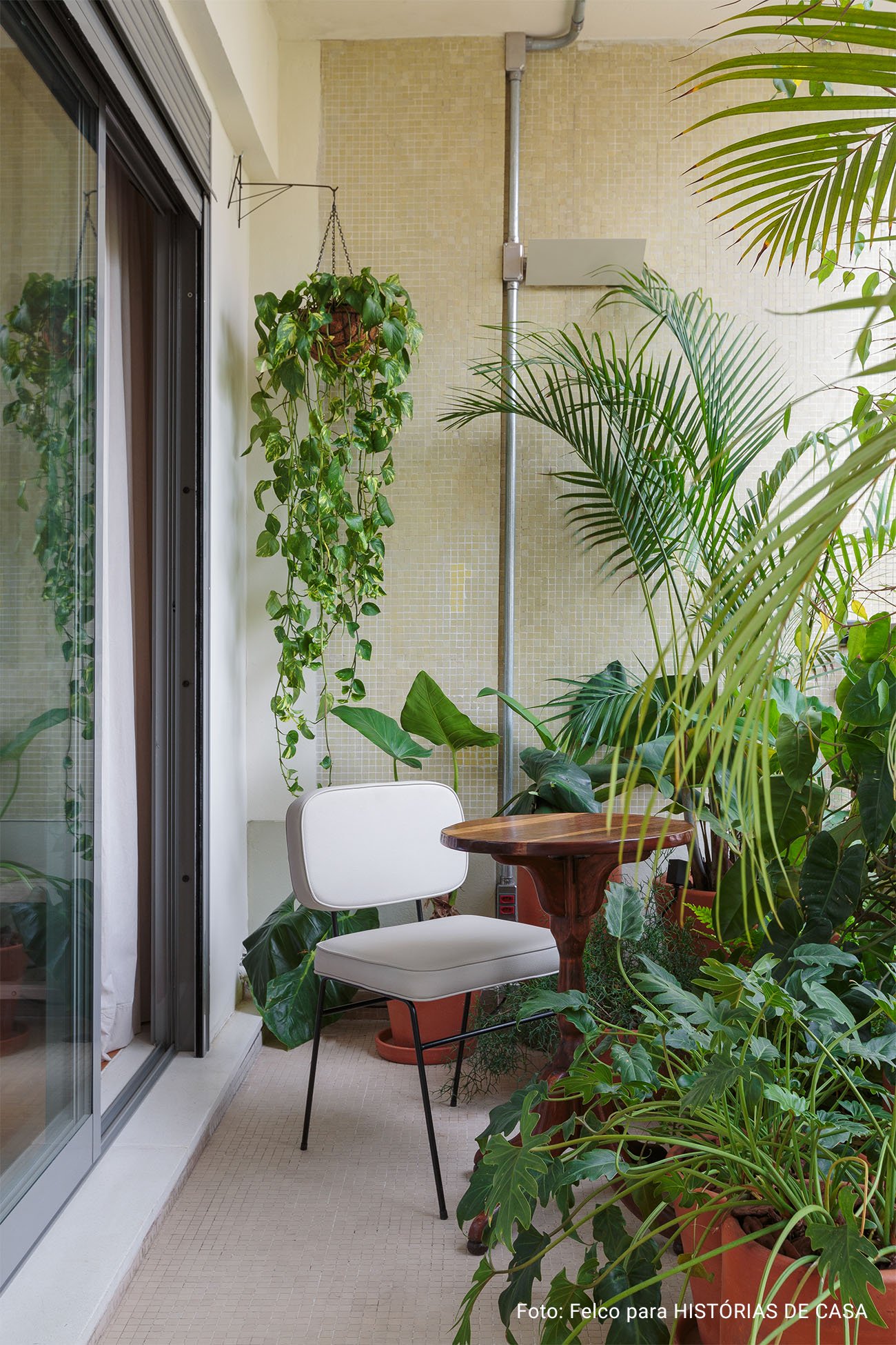 Apartamento conceito no Edifício Vírginia tem cozinha integrada, sacada com plantas, piso de taco e decoração com garimpos.
