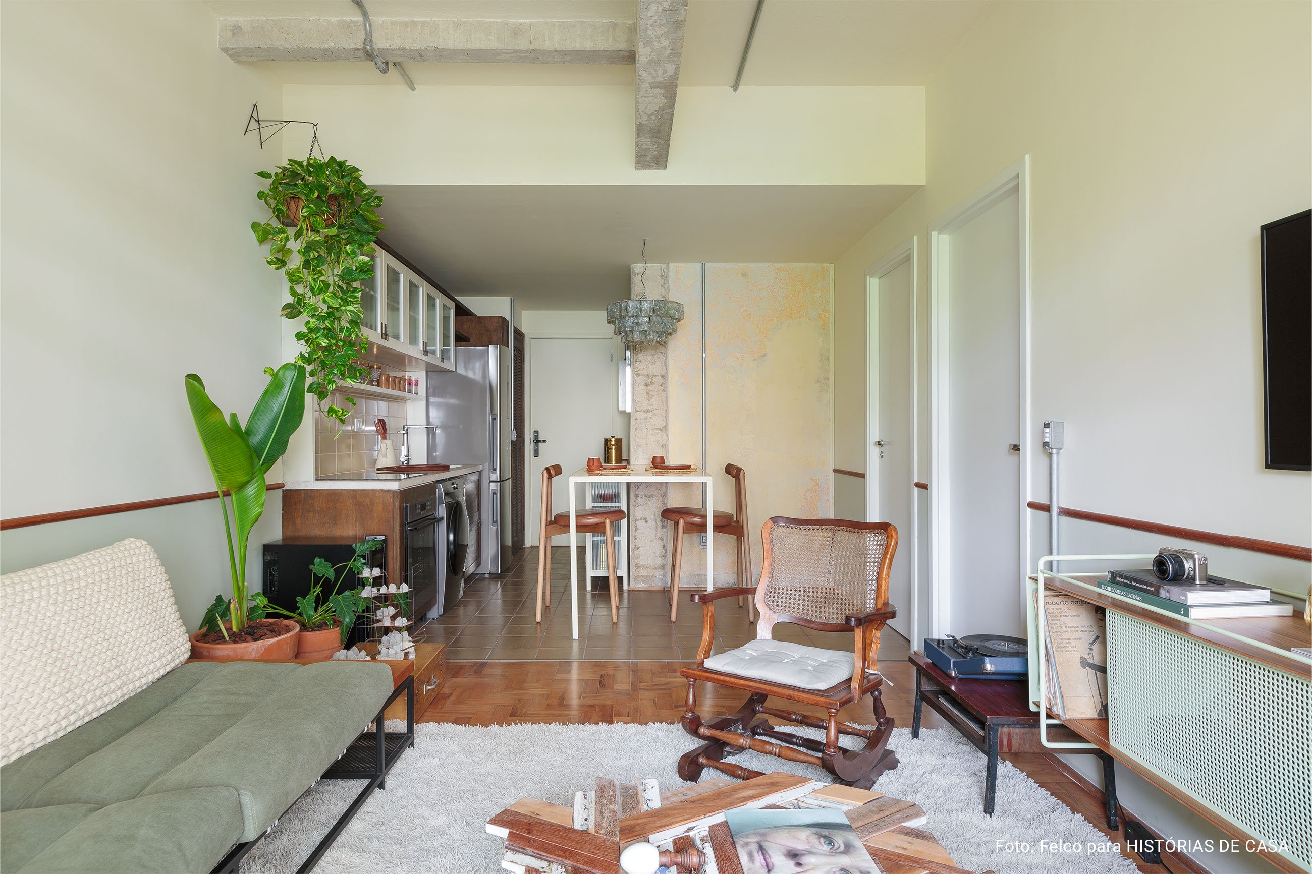 Apartamento conceito no Edifício Vírginia tem cozinha integrada, sacada com plantas, piso de taco e decoração com garimpos.