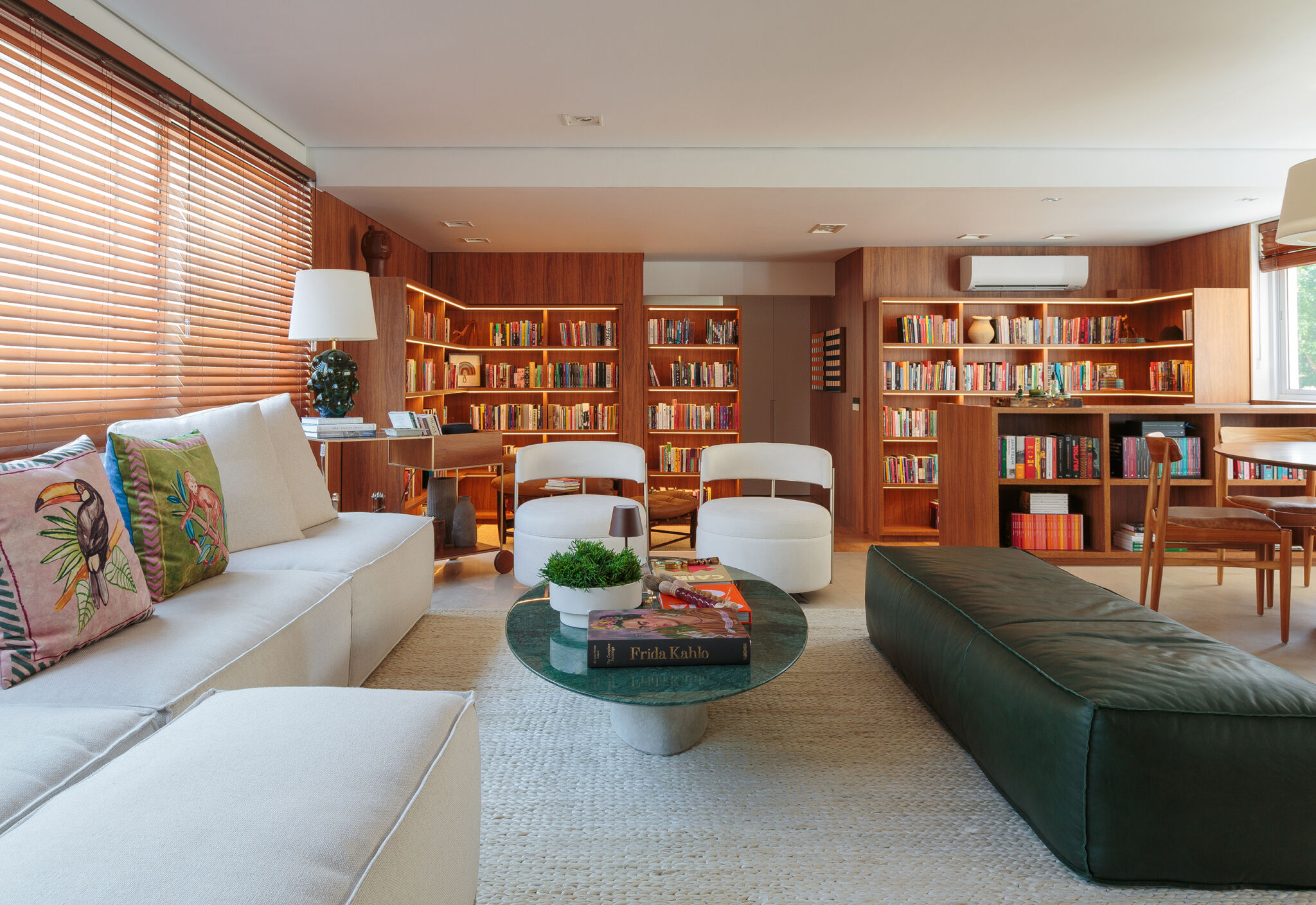 Apartamento integrado com sala aberta e estante de madeira com muitos livros