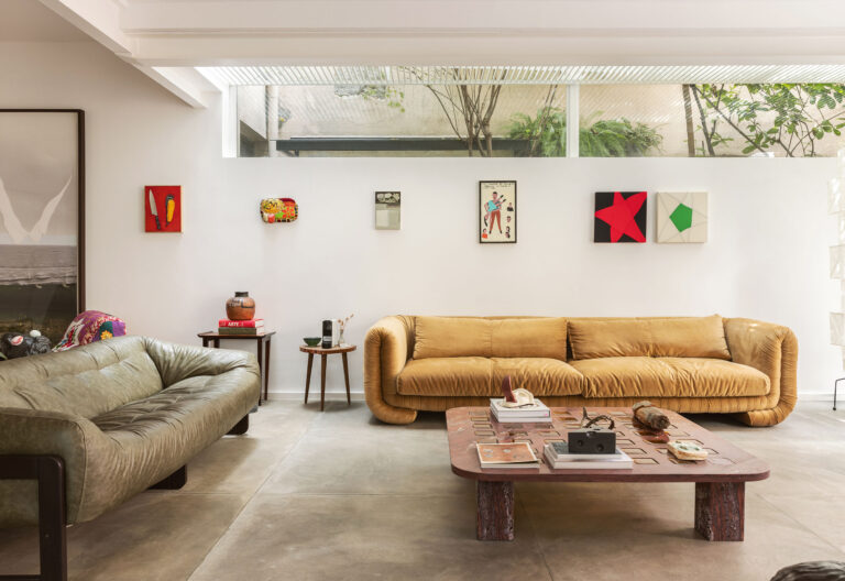 Casa com espaços integrados, muitas obras de arte e área externa cor-de-rosa.