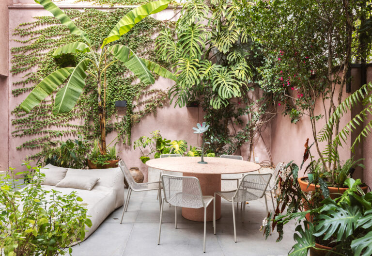 Casa com espaços integrados, muitas obras de arte e área externa cor-de-rosa.