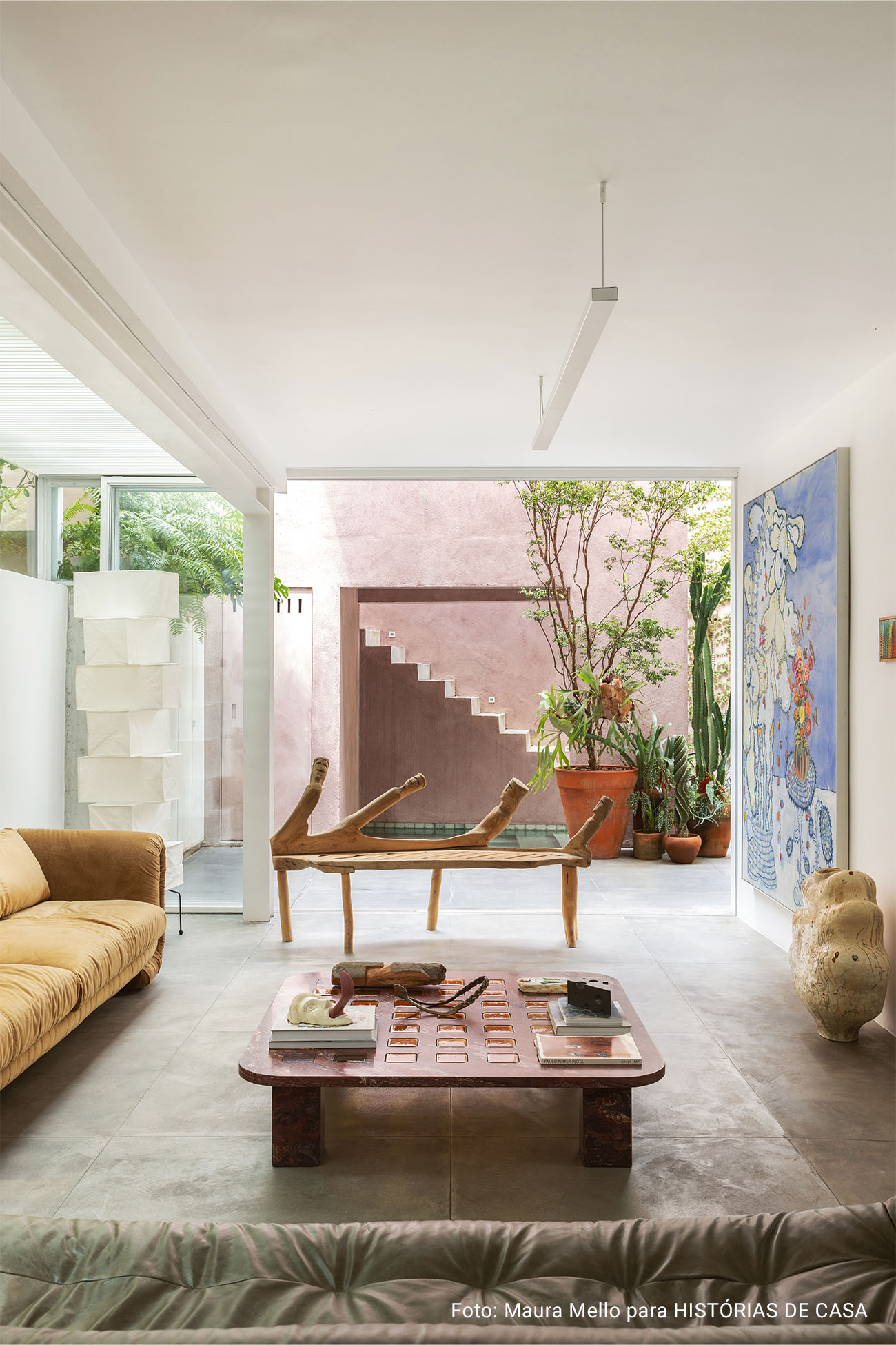 Casa com espaços integrados, muitas obras de arte e área externa cor-de-rosa.