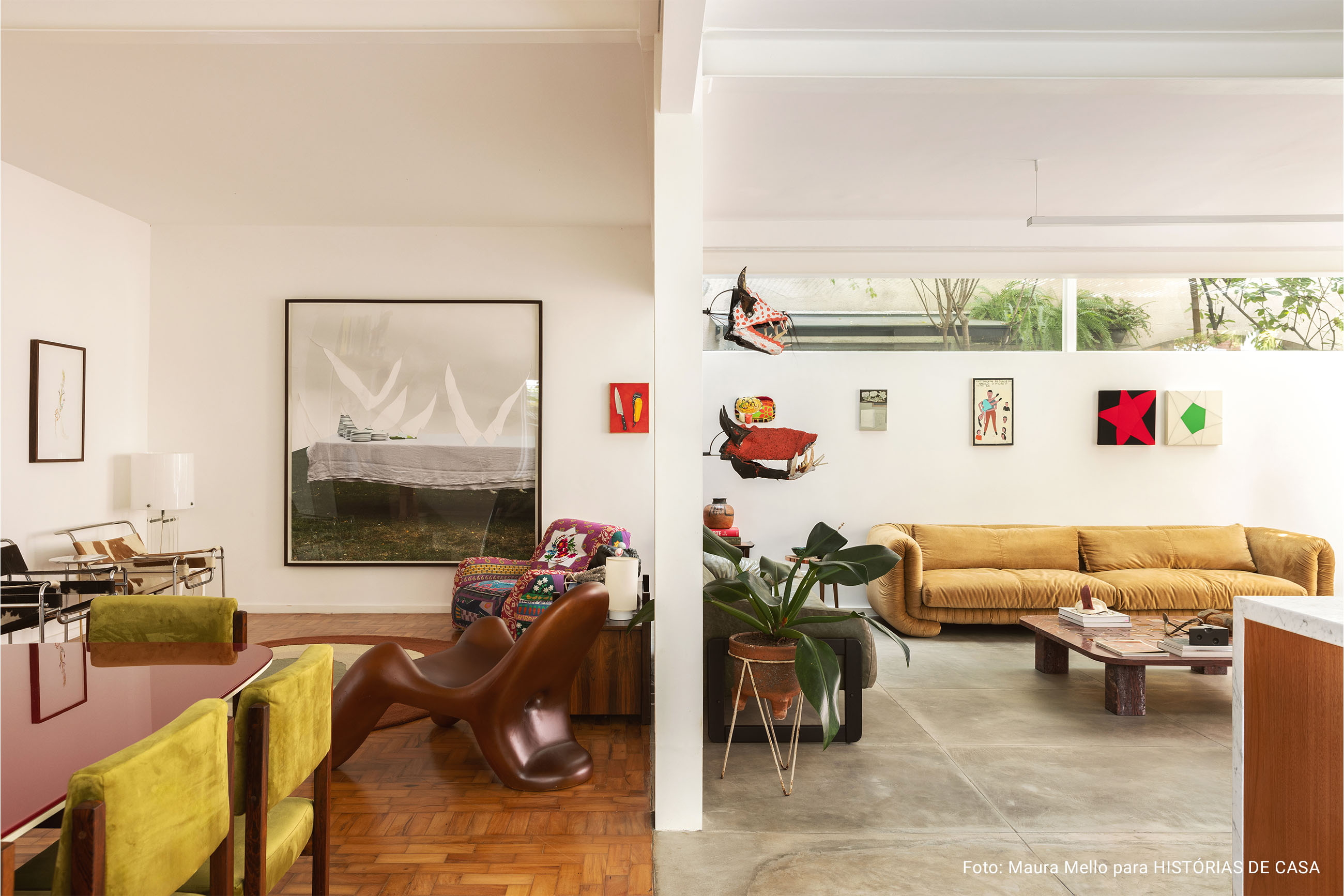 Casa com espaços integrados, muitas obras de arte e área externa cor-de-rosa.