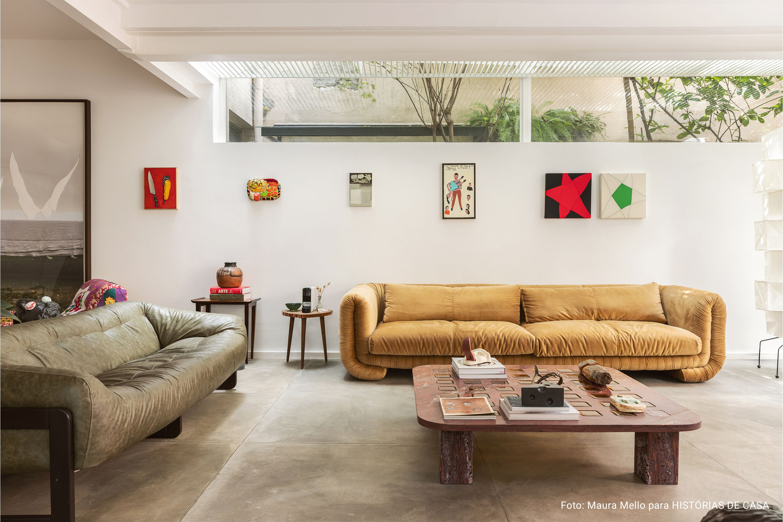 Casa com espaços integrados, muitas obras de arte e área externa cor-de-rosa.