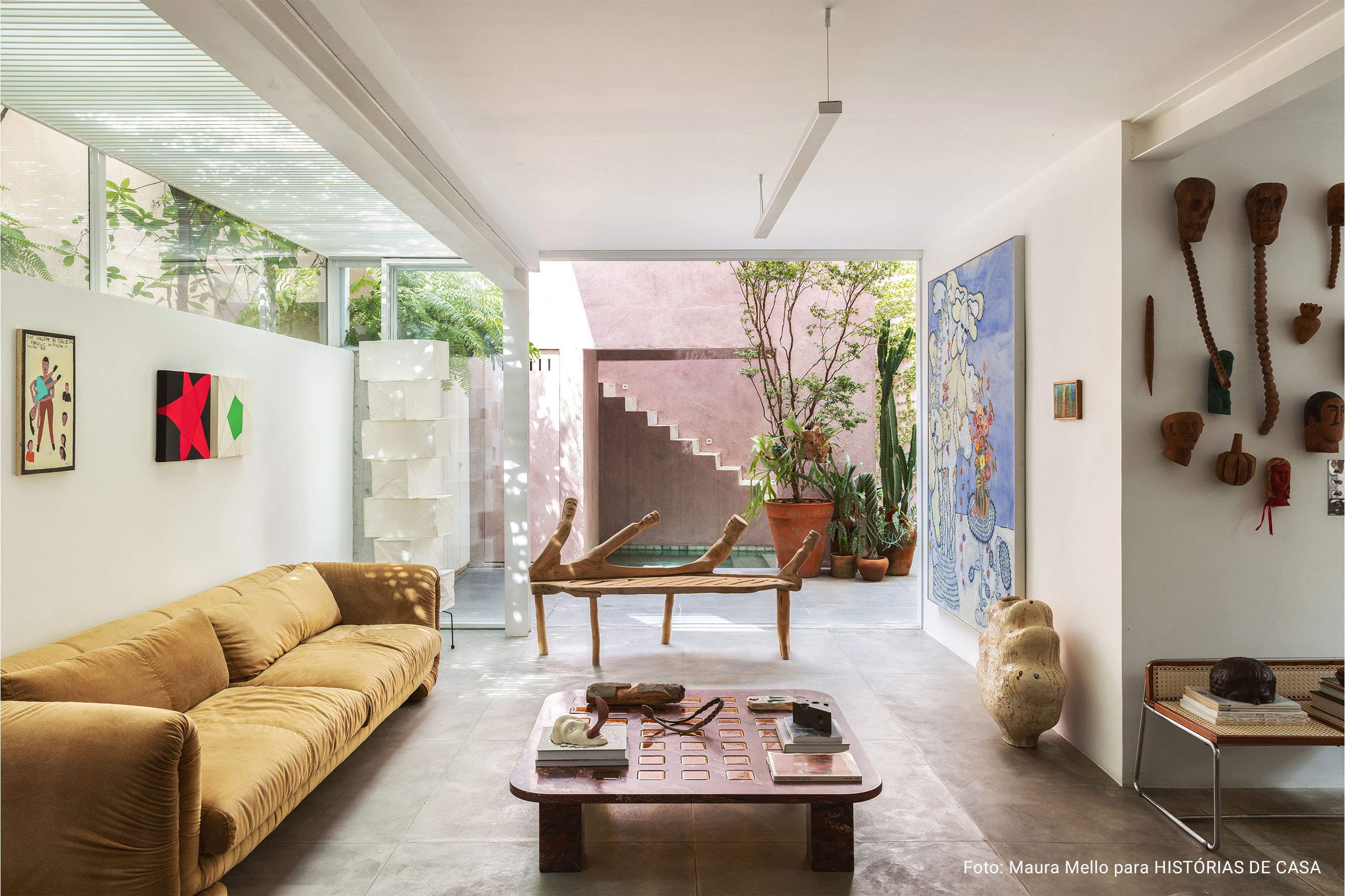 Casa com espaços integrados, muitas obras de arte e área externa cor-de-rosa.