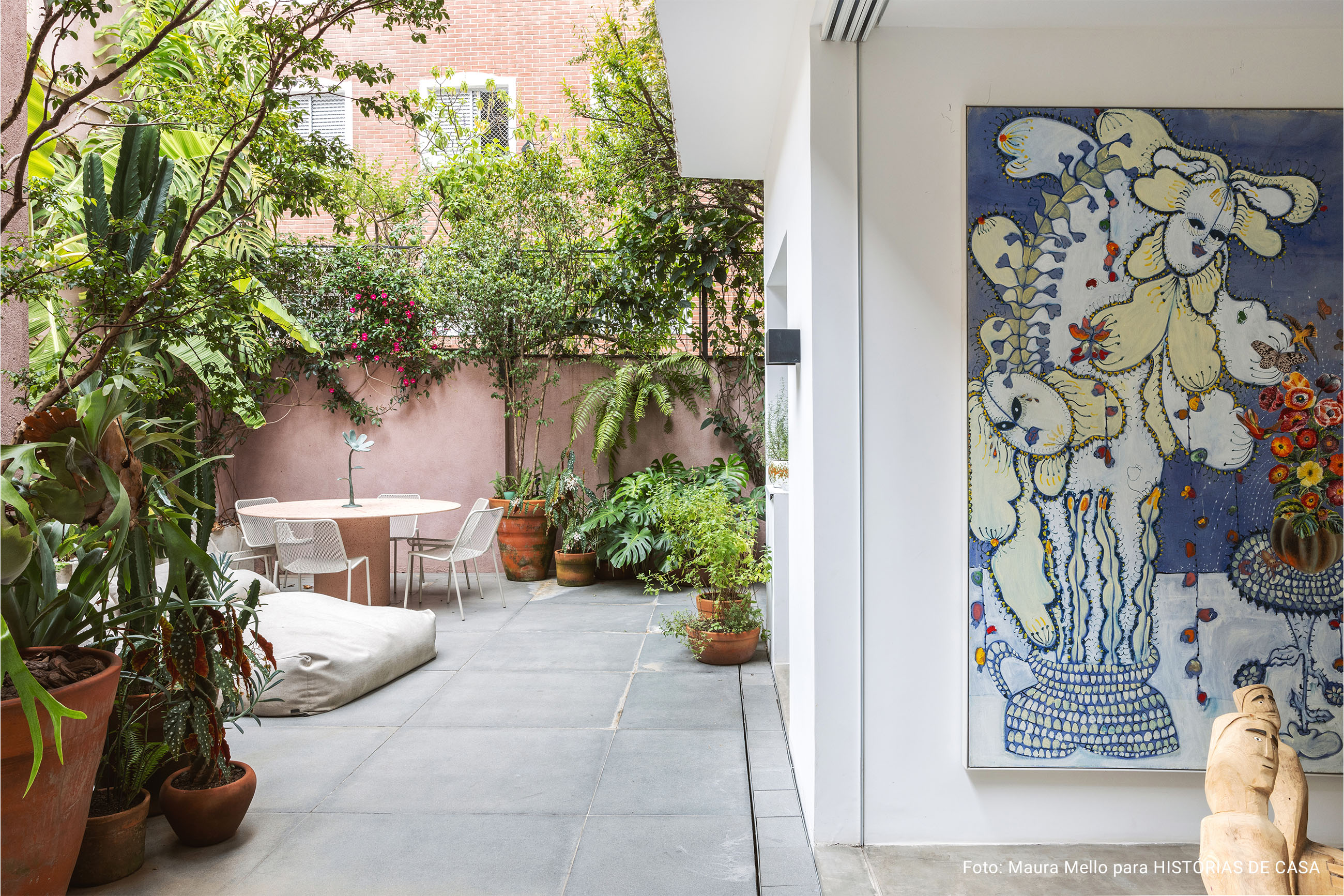 Casa com espaços integrados, muitas obras de arte e área externa cor-de-rosa.