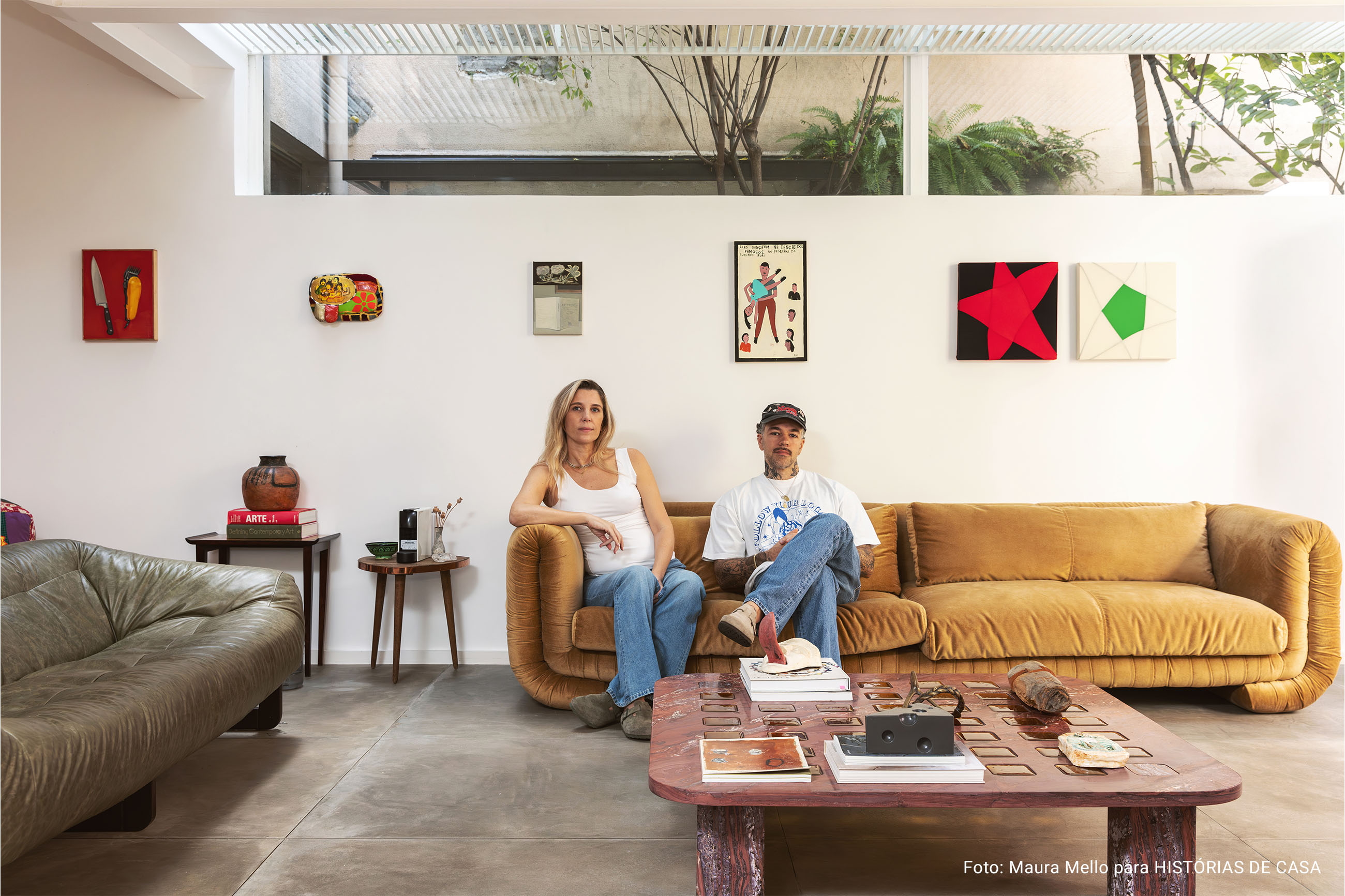 Casa com espaços integrados, muitas obras de arte e área externa cor-de-rosa.