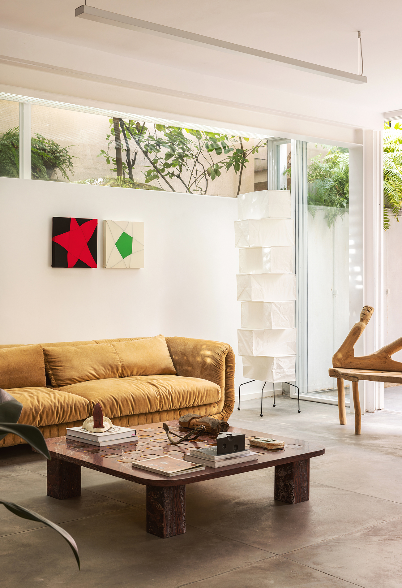 Casa com espaços integrados, muitas obras de arte e área externa cor-de-rosa.