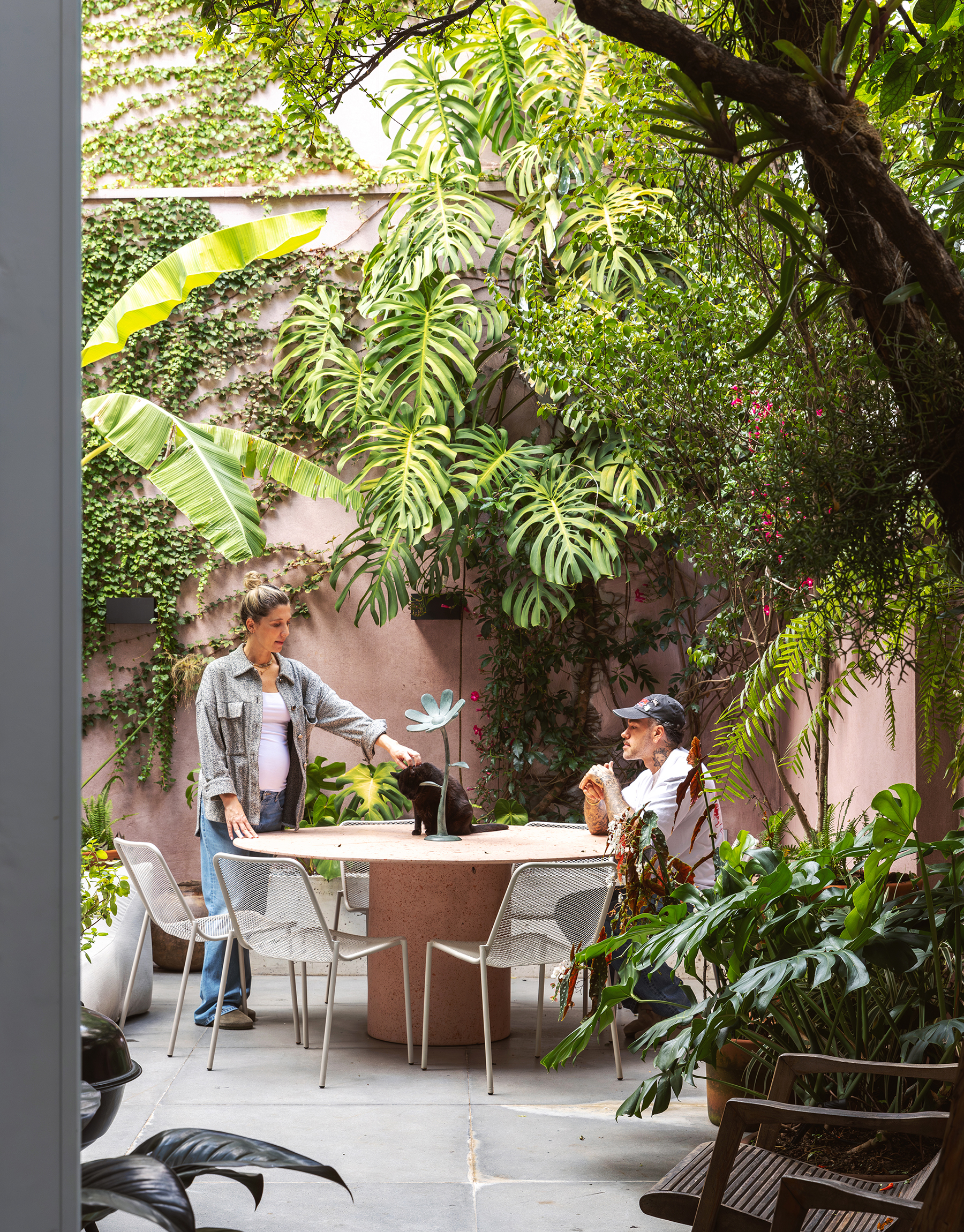 Casa com espaços integrados, muitas obras de arte e área externa cor-de-rosa.