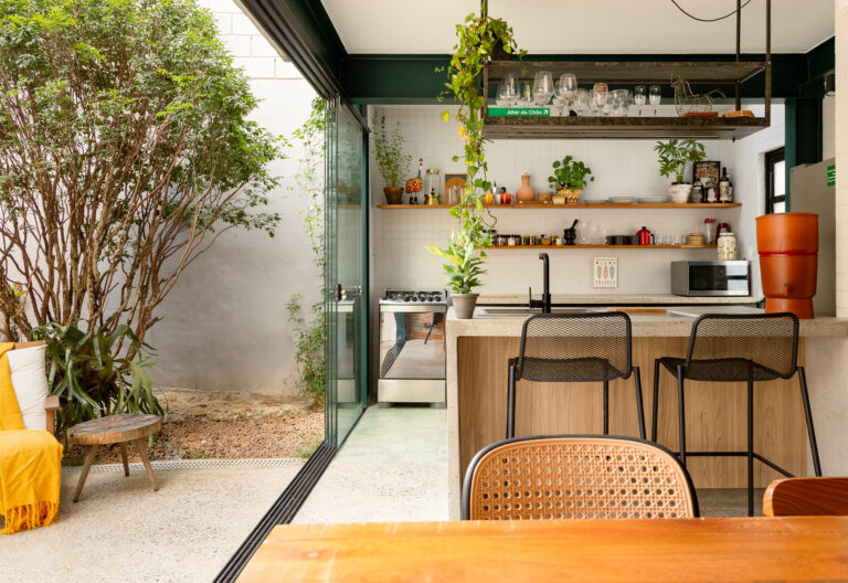 Casa com tijolinhos, cozinha integrada e jardim.