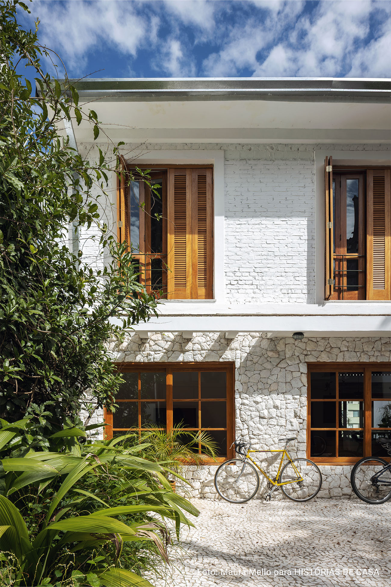Casa com fachada de pedras, janelas de madeira e decoração acolhedora com garimpos