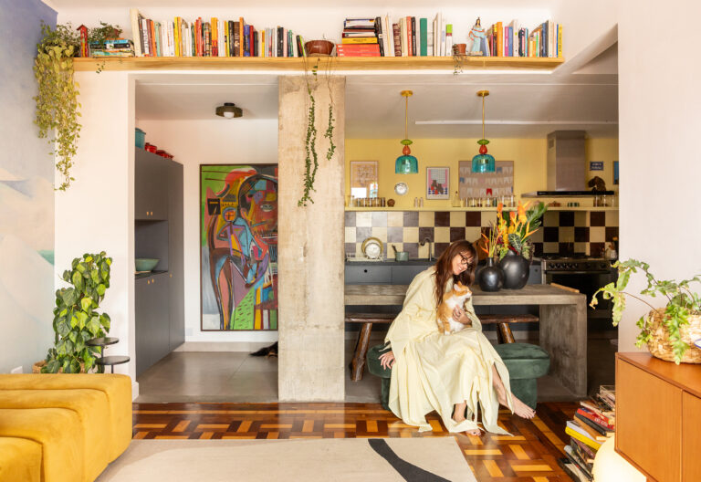 Apartamento maxmalista da Chef Cafira Foz com papel de parede, cozinha aberta com frontão xadrez e esquadrias vermelhas