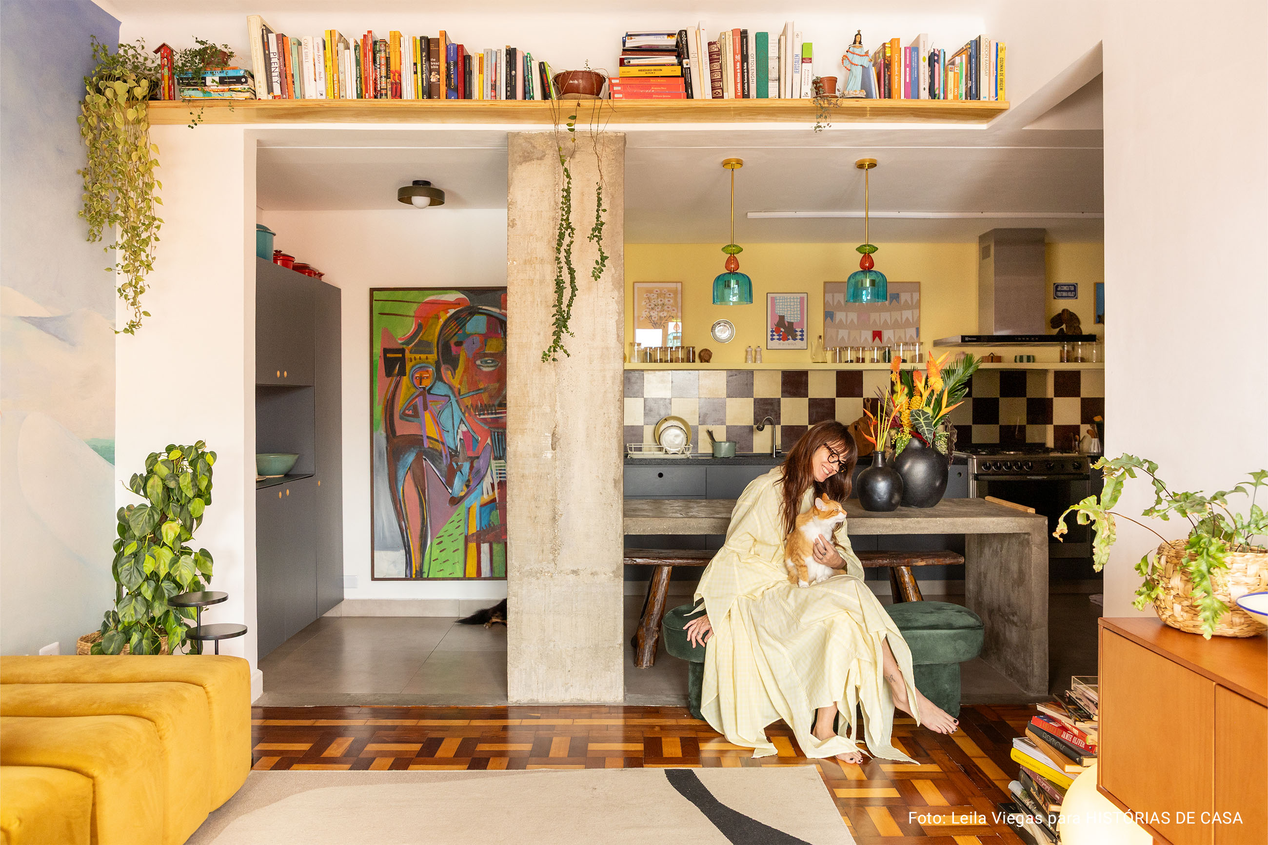 Apartamento colorido com papel de parede, cozinha aberta com frontão xadrez e esquadrias vermelhas