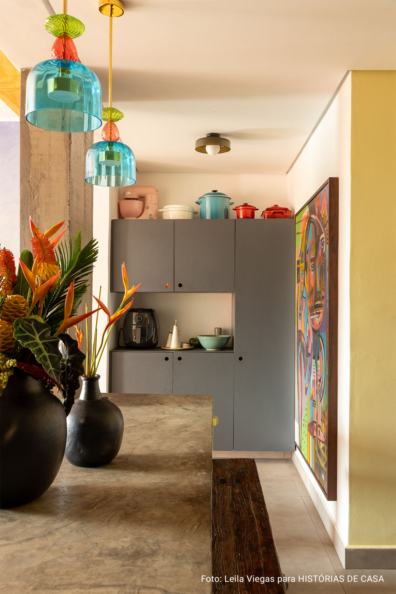 Apartamento colorido com papel de parede, cozinha aberta com frontão xadrez e esquadrias vermelhas