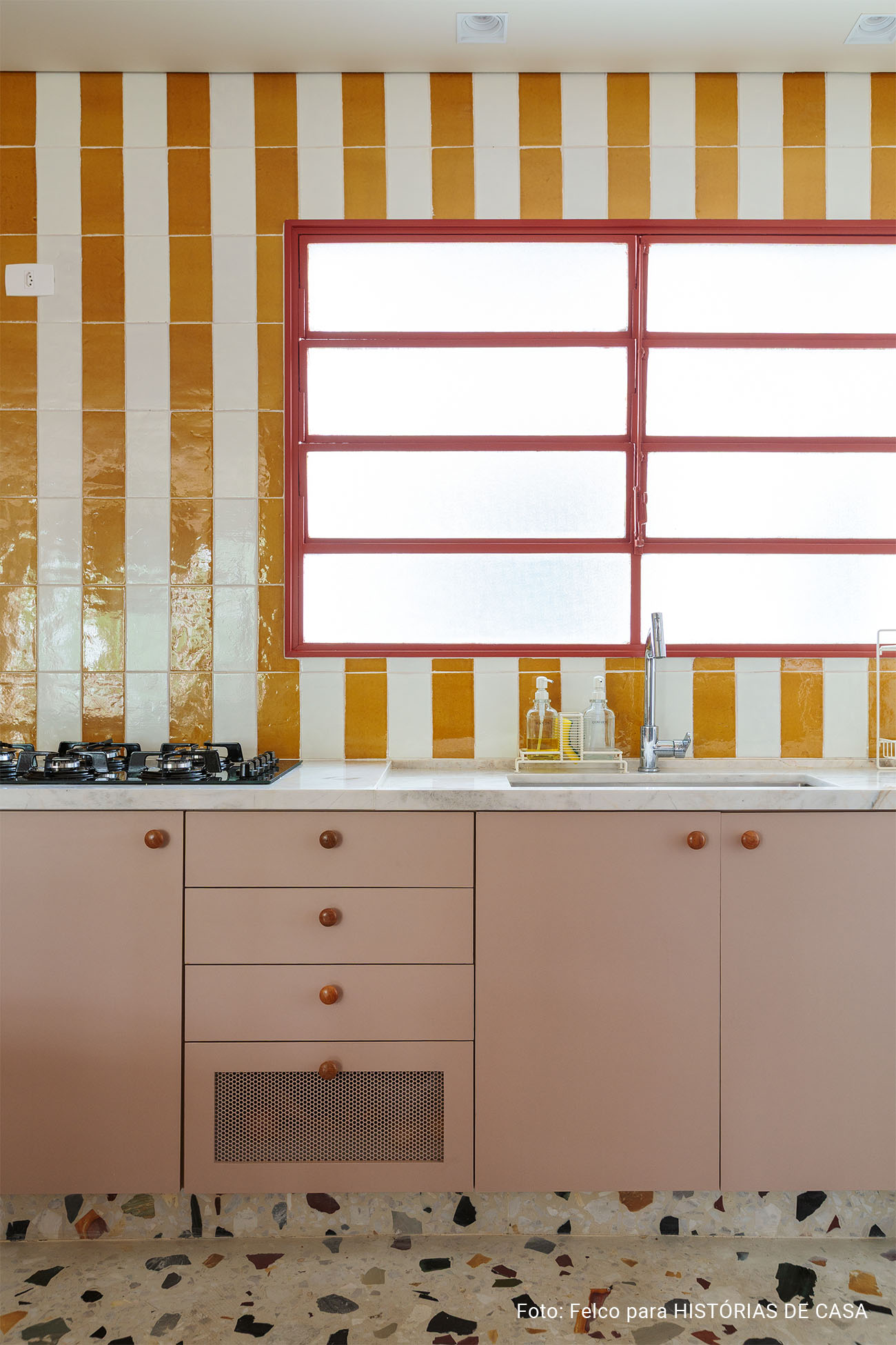 Apartamento reformado com decoração colorida, esquadrias vermelhas e cozinha listrada de amarelo
