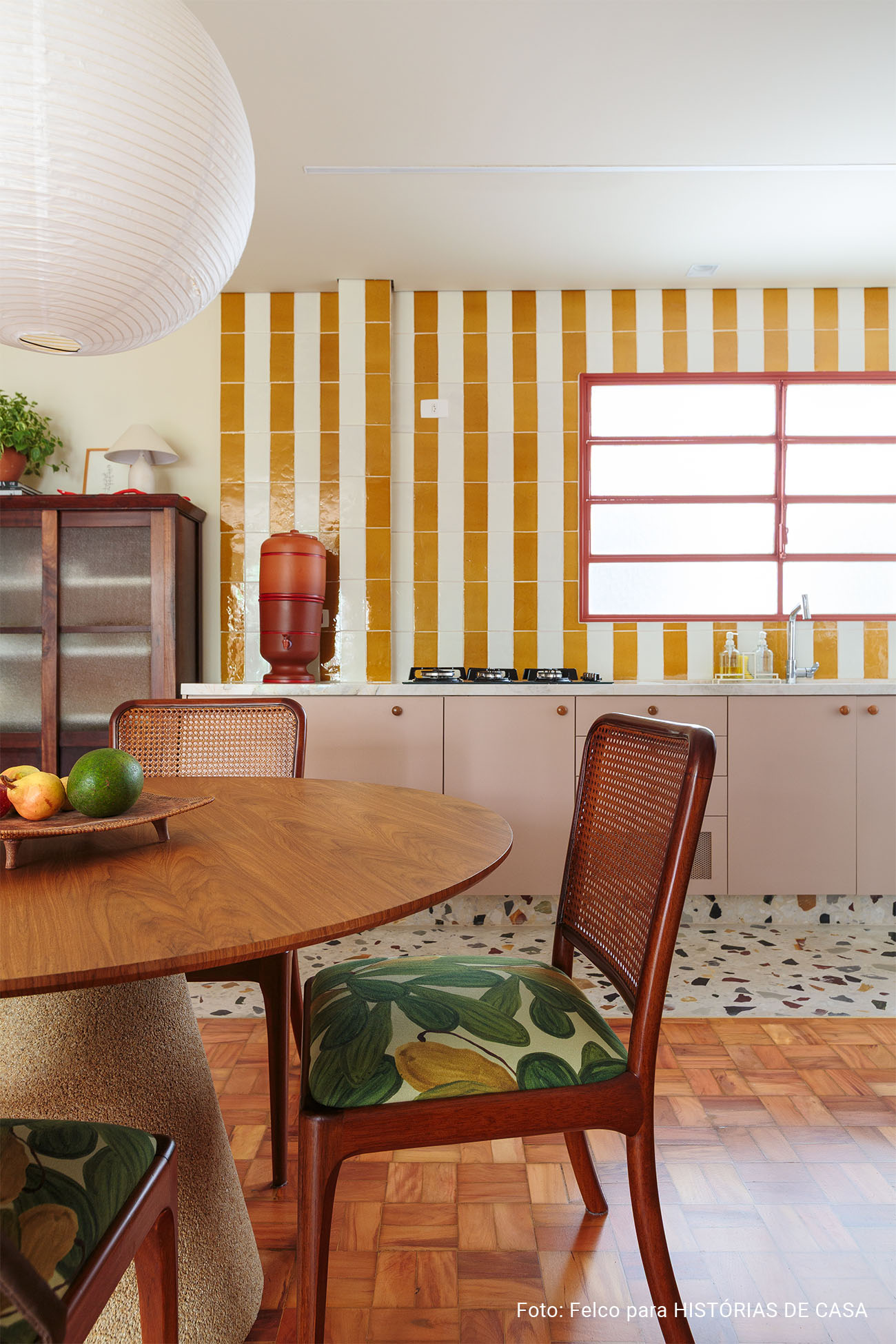 Apartamento reformado com decoração colorida, esquadrias vermelhas e cozinha listrada de amarelo
