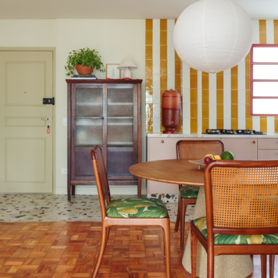 Apartamento reformado com decoração colorida, esquadrias vermelhas e cozinha listrada de amarelo