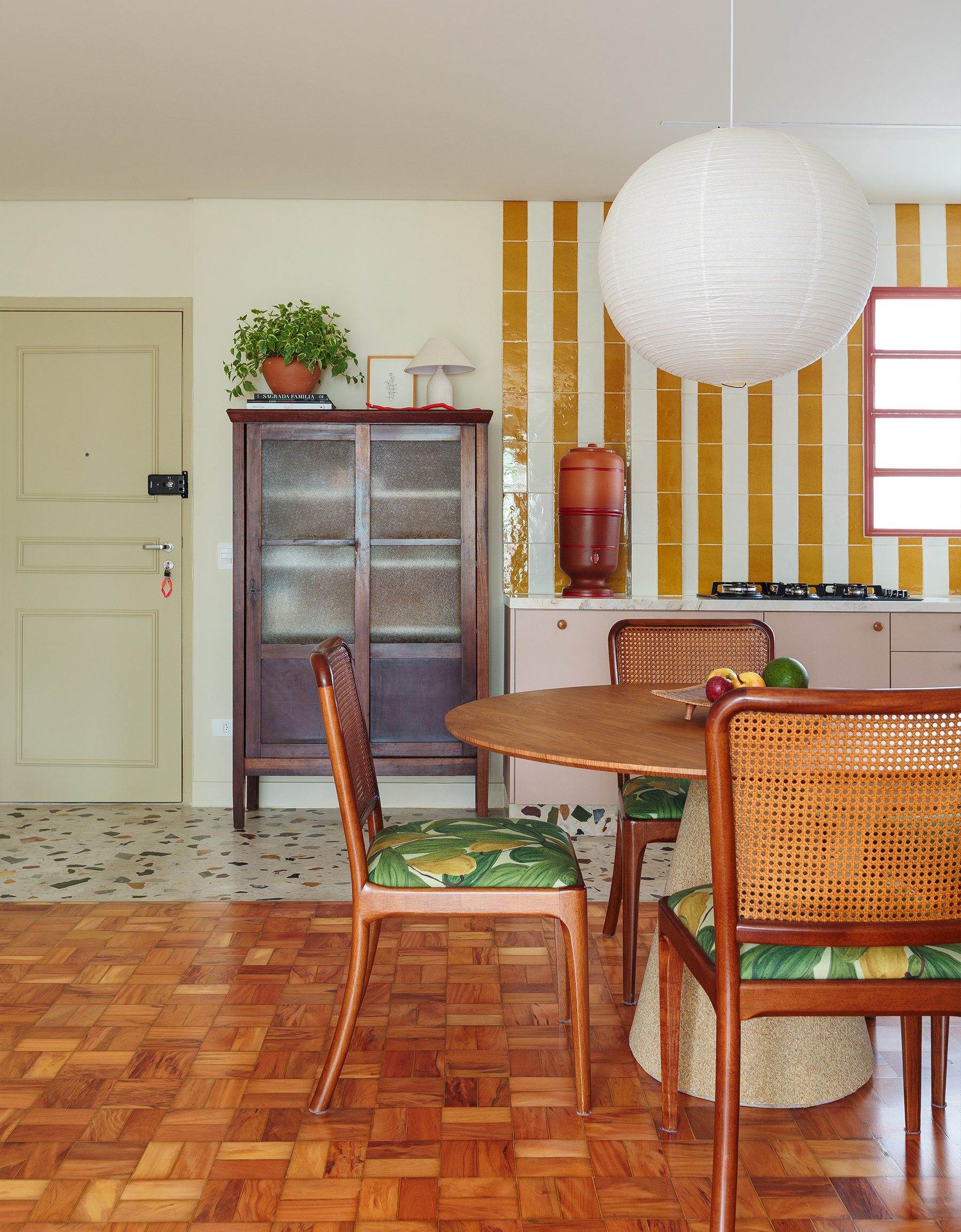 Apartamento reformado com decoração colorida, esquadrias vermelhas e cozinha listrada de amarelo